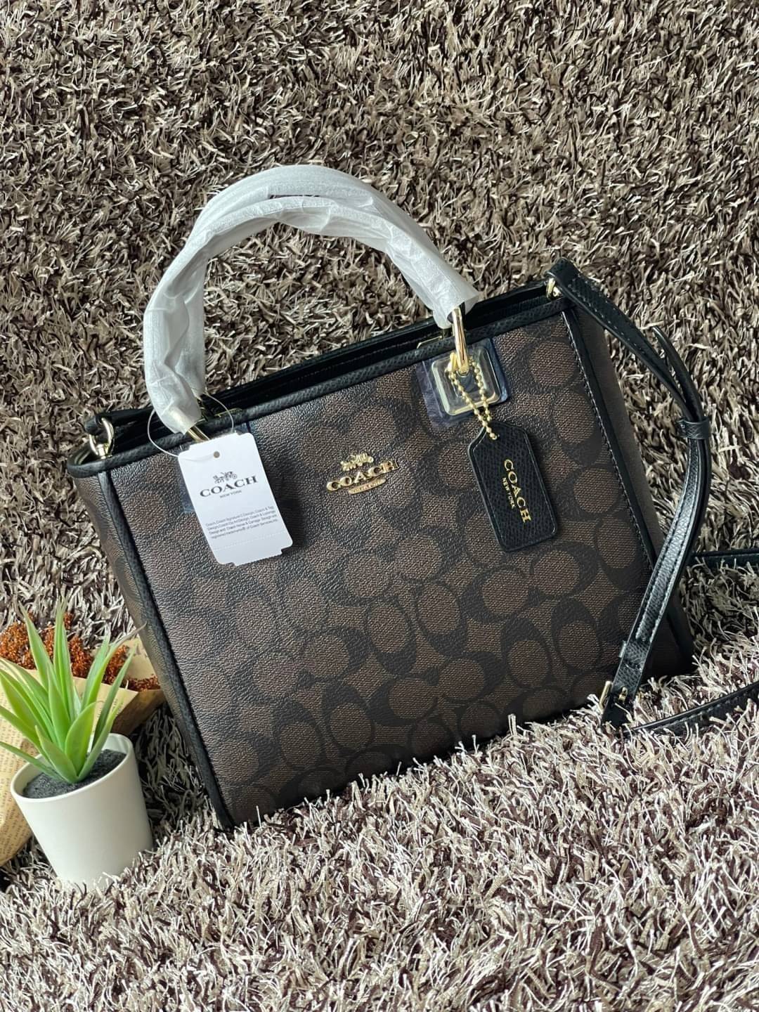 Coach Perry Tote Classic Bag F57568 รุ่นใหม่ล่าสุด กระเป๋ารูปทรงสี่เหลี่ยมสุดคลาสสิก เป็นกระเป๋าอเนกประสงค์ที่สามารถใช้ได้แทบทุกโอกาส ไม่ว่าจะไปเรียน, ไปทำงาน, ไปเที่ยว หรือแม้แต่ไปชอปปิง ด้วยขนาดที่กำลังดี ไม่ใหญ่เทอะทะ แต่ก็ไม่เล็กจนเกินไป มาพร้อมหูหิ้ว