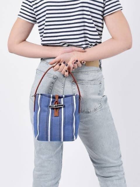 LONGCHAMP ROSEAU ESSENTIAL RAYÉ Bucket bag S - Blue สำหรับใครที่ต้องการกระเป๋าแบบใช้งานได้ในหลาย ๆ โอกาส สีสันกระเป๋าสามารถแมทช์ได้ง่ายกับเสื้อผ้า Longchamp รุ่นนี้สามารถตอบโจทย์ เป็นกระเป๋าที่ขนาดกำลังพอดี