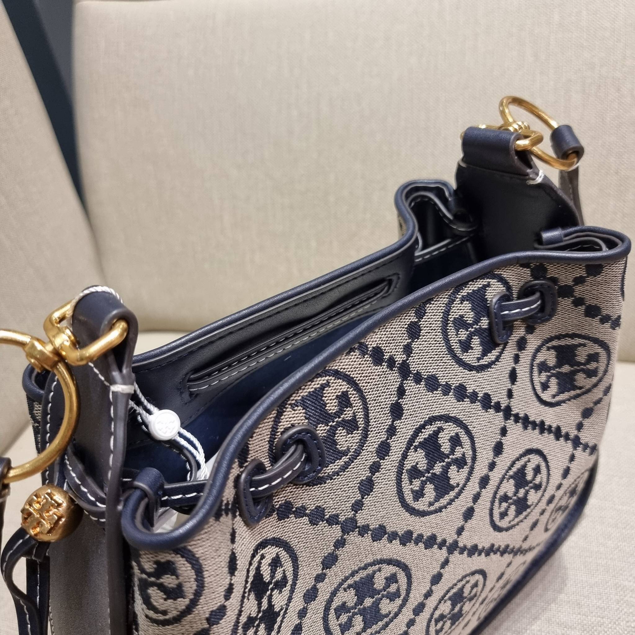 TORY BURCH T MONOGRAM JACQUARD BELL BAG คอลเลคชั่นใหม่ กับกระเป๋าลายโมโนแกรมยอดฮิต ที่มาในรูปทรงดีไซน์สวยเก๋ ชิคๆคูลๆ รับรองว่าไม่มีเกร่อ ตัวกระเป๋าทรงเหลี่ยม รูปเก็บทรงได้ในส่วนของปากกระเป๋า หรือไม่รูด ก็ได้ความสวยไปอีกแบบ วัสดุผ้า jacquard ตัดสลับหนังแท