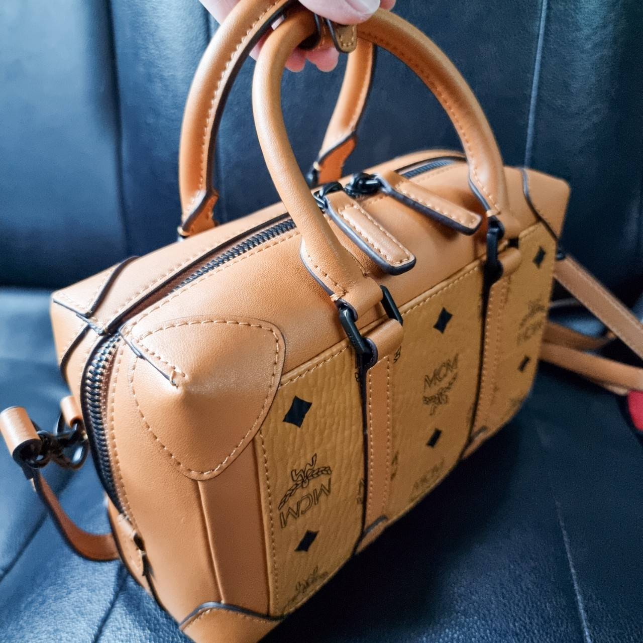 M.C.M SMALL E/W SOFT BERLIN CROSSBODY IN VISETOS ไอเท็มใหม่ในดีไซน์ทรงกระเป๋าเดินทางแบบคลาสสิค ย่อส่วนมาให้ใช้งานได้แบบสบายๆ พกพาสะดวก แมทช์ได้ทุกสไตล์ ใช้ได้แบบ unisex ใช้งานง่ายด้วยหูจับในตัว และซิปหลัก อะไหล่สีดำดูมีมิติตัดกับสีน้ำตาลคอนยัคได้เป็นอย่าง