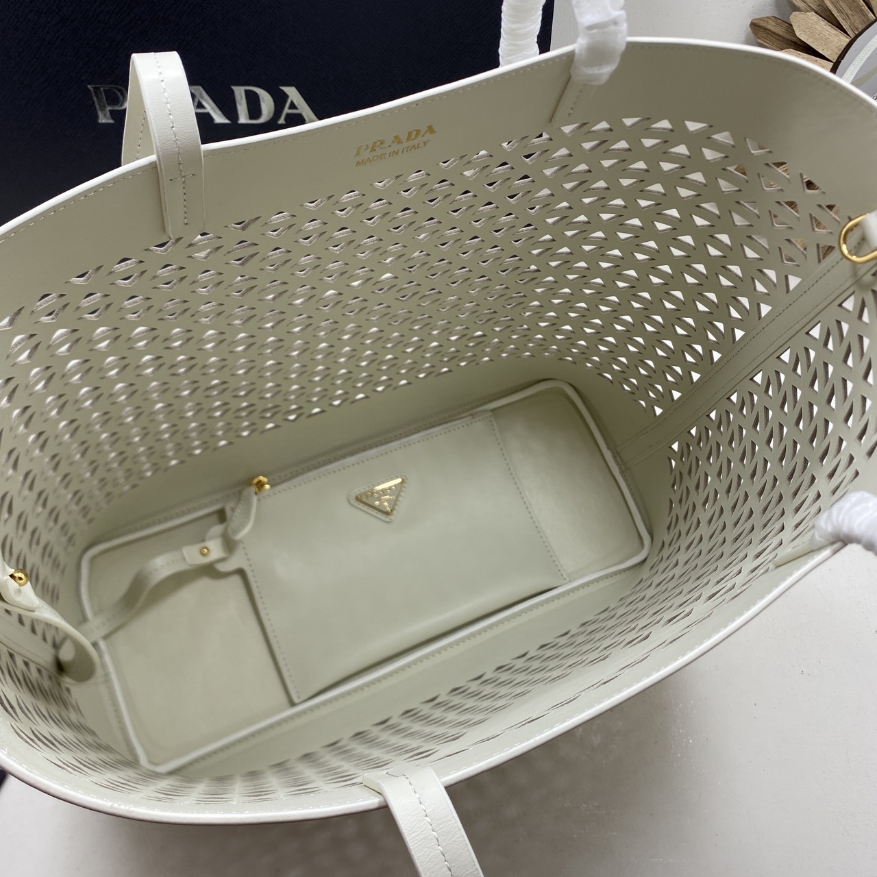 TOP ORI หนังแท้ | Prada Large perforated leather tote bag กระเป๋าทรงโท้ทใบใหญ่ ใจบางที่สุดกับคอลเลคชั่นนี้ ที่เพิ่มดีเทลความแพงด้วยการฉลุลวดลายรอบใบ ถักทอเป็นเส้นลายสานที่สวยงามมาก งานฝีมือจริงๆ