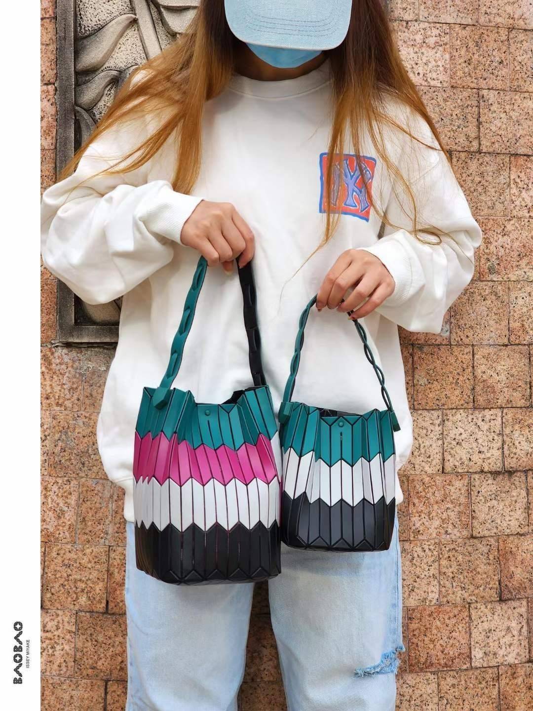 Large : Baobao Issey Miyake Large Bucket กระเป๋าบัคเก็ตขนาดใหญ่สามารถใช้ใส่ร่มพับได้หรือขวดน้ำขนาดเล็กได้ ซีรีย์ใหม่นี้มีจุดเด่นที่แผ่นรูปทรงสี่เหลี่ยมด้านขนานในแนวตั้ง เกิดเป็นรูปทรงสามมิติซึ่งแตกต่างไปจากรูปทรงที่เกิดขึ้นจากแผ่นสามเหลี่ยม หูหิ้วสามารถขย