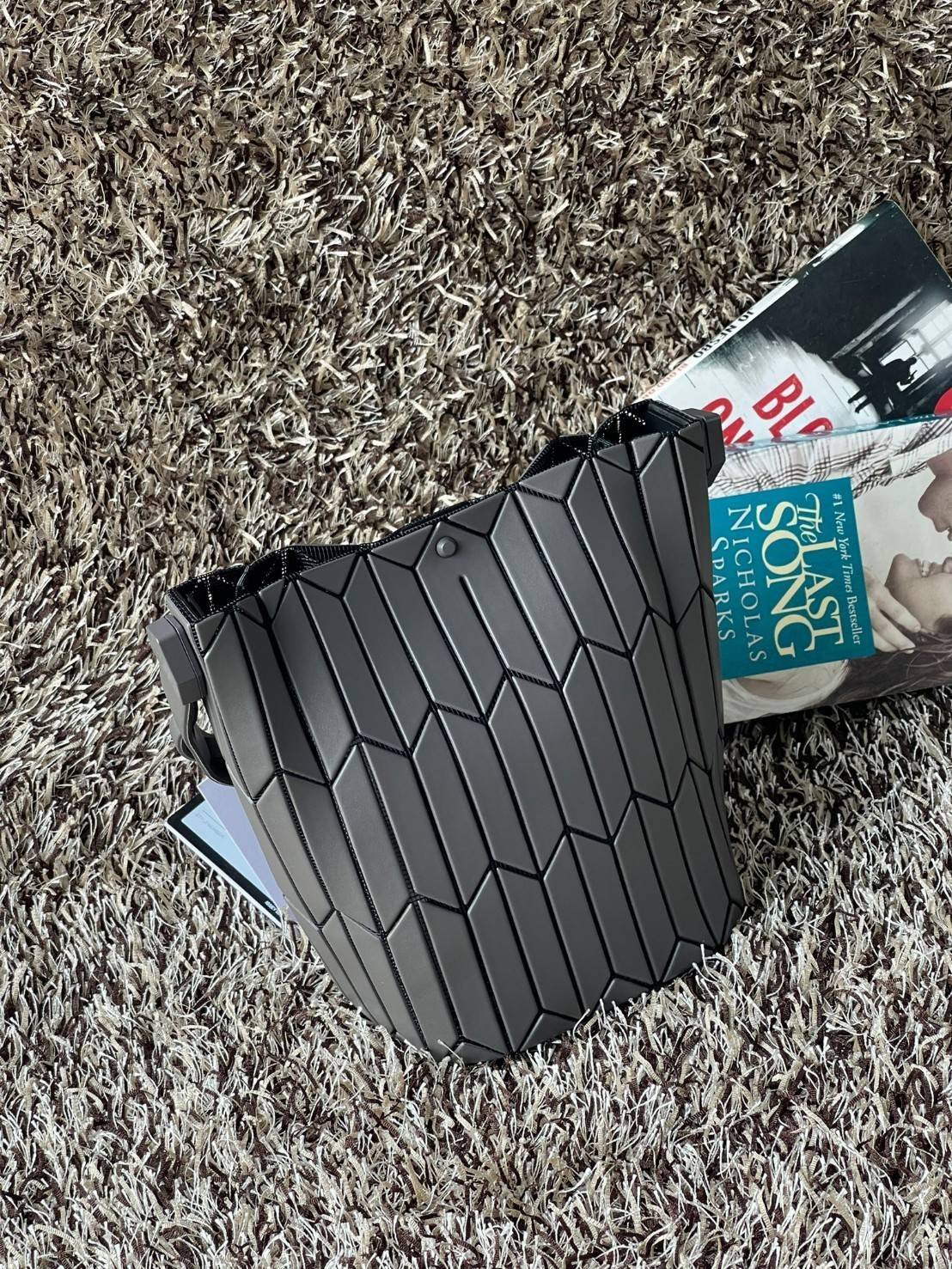 Small : BAO BAO ISSEY MIYAKE SMALL BUCKET เป็นกระเป๋าบัคเก็ตขนาดเล็กสามารถใช้ใส่กระเป๋าสตางค์และโทรศัพท์มือถือได้ ซีรีย์ใหม่นี้มีจุดเด่นที่แผ่นรูปทรงสี่เหลี่ยมด้านขนานในแนวตั้ง เกิดเป็นรูปทรงสามมิติซึ่งแตกต่างไปจากรูปทรงที่เกิดขึ้นจากแผ่นสามเหลี่ยม หูหิ้ว