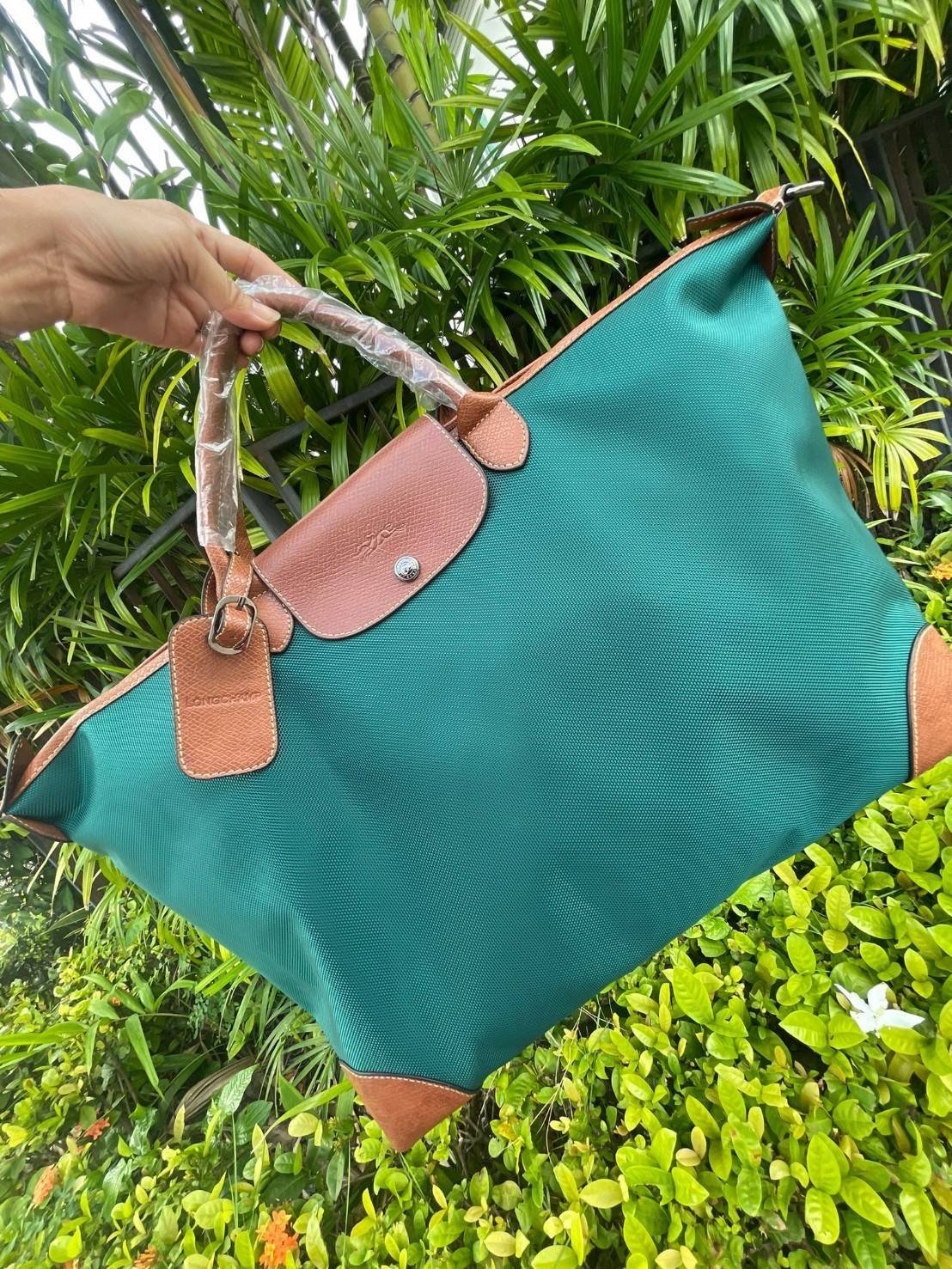 LONGCHAMP BOXFORD TRAVEL BAG L กระเป๋าเดินทางขนาดใหญ่ มาพร้อมสายสะพายที่สามารถถอดได้ ให้คุณเลือกสะพายไหล่หรือถือได้ มีซิปรูดเปิดปิดกระเป๋าที่ให้คุณมั่นใจได้ว่าคุณจัดเก็บไอเท็มของคุณได้อย่างมิดชิด บ็อคฟอร์ด (BOXFORD) สะท้อนความเป็นเอกลักษณ์ของแบรนด์ที่เปี่