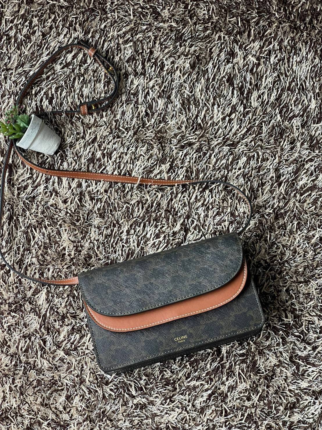 CELINE WALLET ON STRAP IN TRIOMPHE CANVAS กระเป๋าสะพายไหล่สุดเก๋ใบนี้ผลิตจากผ้าใบเคลือบอย่างดีพร้อมขอบหนังสีน้ำตาล กระเป๋ามีสายสะพายหนังสีน้ำตาลพร้อมฮาร์ดแวร์สีทอง ถอดสายออกเพื่อเป็นกระเป๋าถือทรงคลัชท์เปลี่ยนลุคช์ ลวดลายtriomphe ความเป็นแบรนด์ CELINE ได้อ