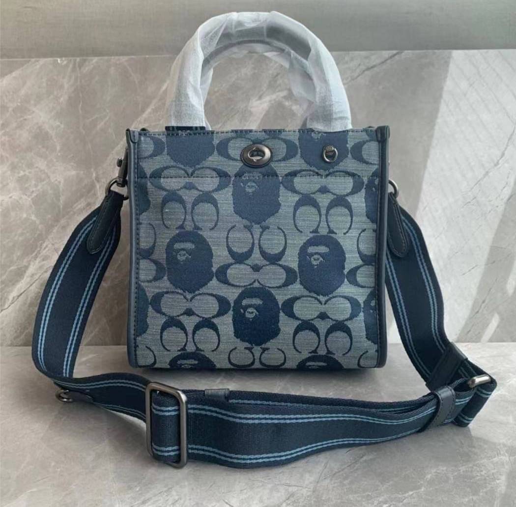 Coach Bape X Coach Tote 22 In Signature Jacquard กระเป๋าถือและครอสบอดี้โท้ทมินิไซส์ รุ่นใหม่สุดฮอต!! ใบจริงคือน่ารักม้ากกกก!! สวยอยู่ทรง มี 2 สี น่ารักน่าใช้ วัสดุหนังแคนวาส มาพร้อมหูจับในตัวและสายสะพายข้าง ถอดออกหิ้วเก๋ๆก็ได้ หรือสะพายถ่ายรูปชิคๆก็ดูดี ล