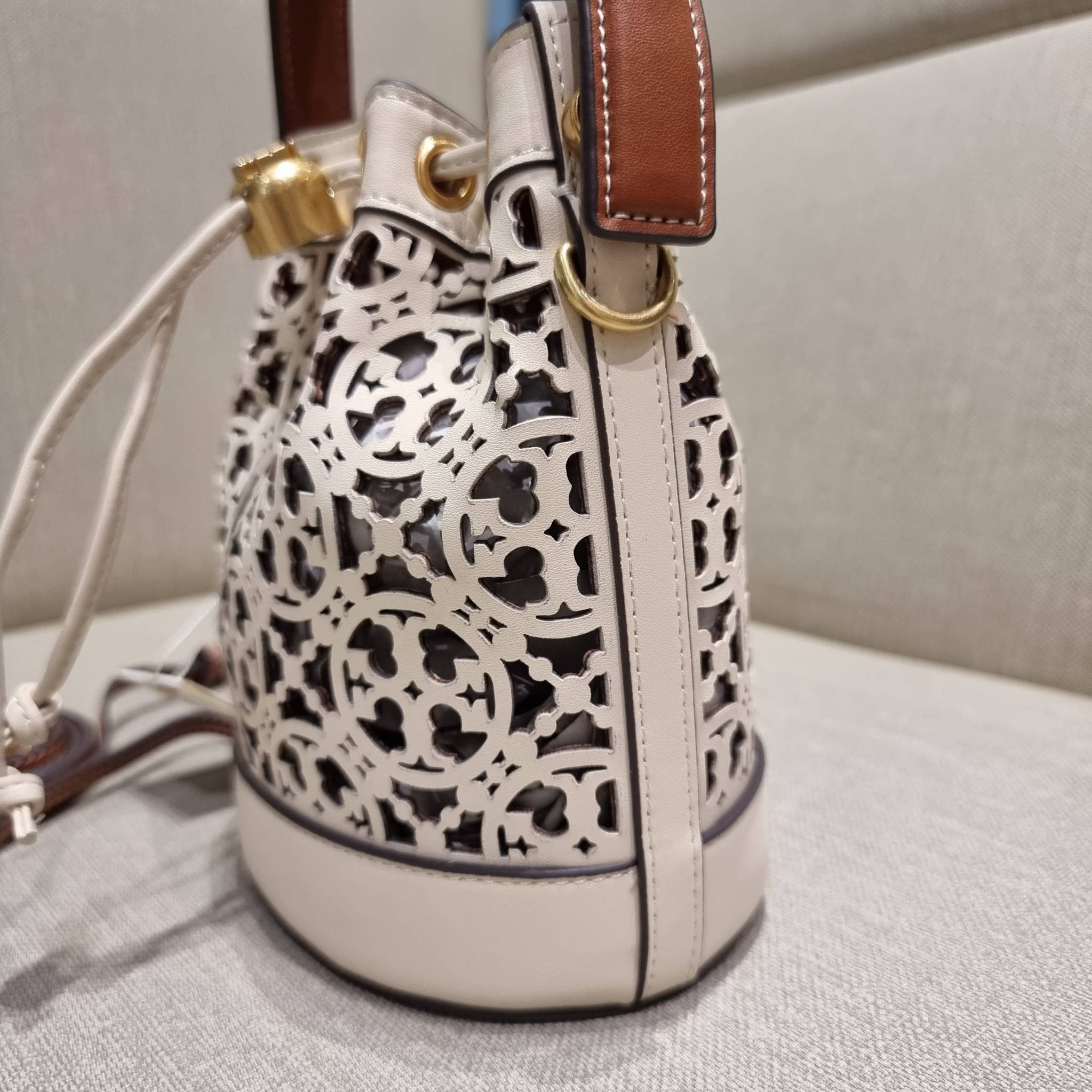 TORY BURCH T MONOGRAM LASER-CUT MINI BUCKET BAG ใจบางที่สุดกับคอลเลคชั่นนี้ กับกระเป๋าสะพายทรงบัคเก็ต ไซส์มินิ รุ่นชูโรงสุดฮิต ที่เพิ่มดีเทลความแพงด้วยการฉลุลวดลายโมโนแกรมรอบใบ ถักทอเป็นเส้นลายสานที่สวยงามมาก งานฝีมือจริงๆ วัสดุหนัง cowhide รูดเปิด-ปิดด้ว