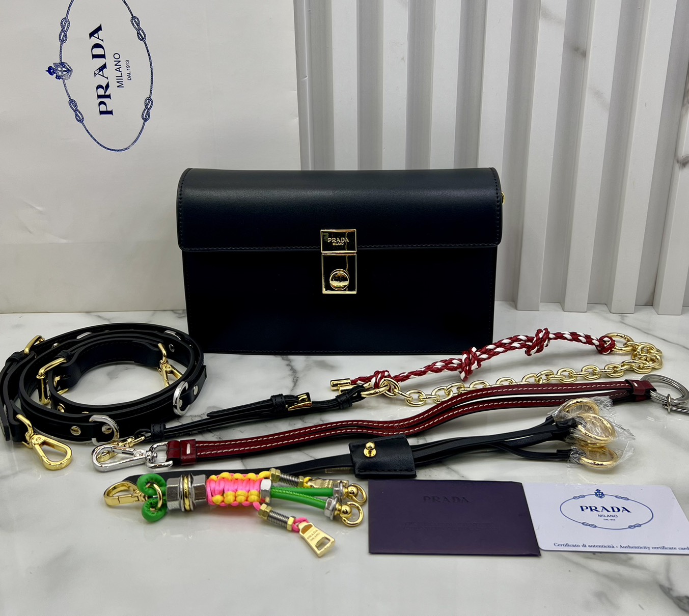 ORI หนังแท้ | 22cm Prada Soft Sound small leather shoulder bag with charms กระเป๋าสะพายทรงกล่อง รุ่นใหม่ล่าสุด มาแรงแบบเกินต้าน ด้วยดีไซน์เรียบ แต่มีกิมมิคเท่ห์ๆ ที่สายและพวงห้อยหลากสีสุดคิวท์