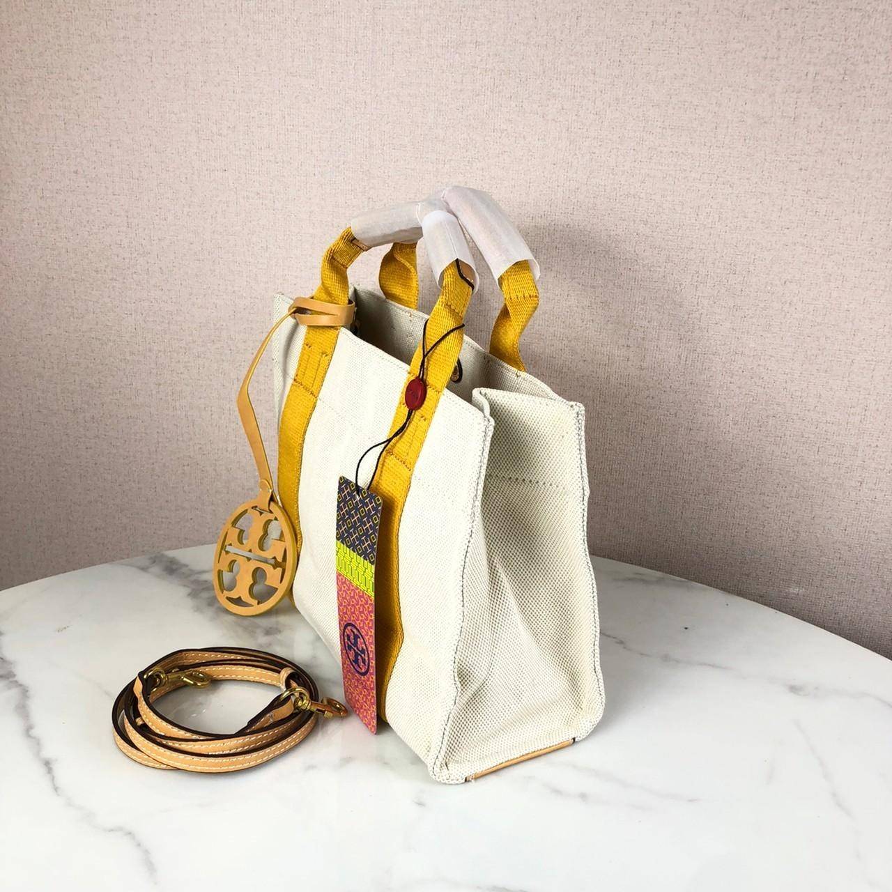 กระเป๋าถือ หรือสะพาย TORY BURCH เปิด - ปิดกระเป๋าด้วยกระดุม ด้านในมีช่องซิป 1 ช่อง และช่องใส่ของ 1 ช่อง มาพร้อมสายสะพาย สามารถถอดและปรับได้ 3 ระดับ