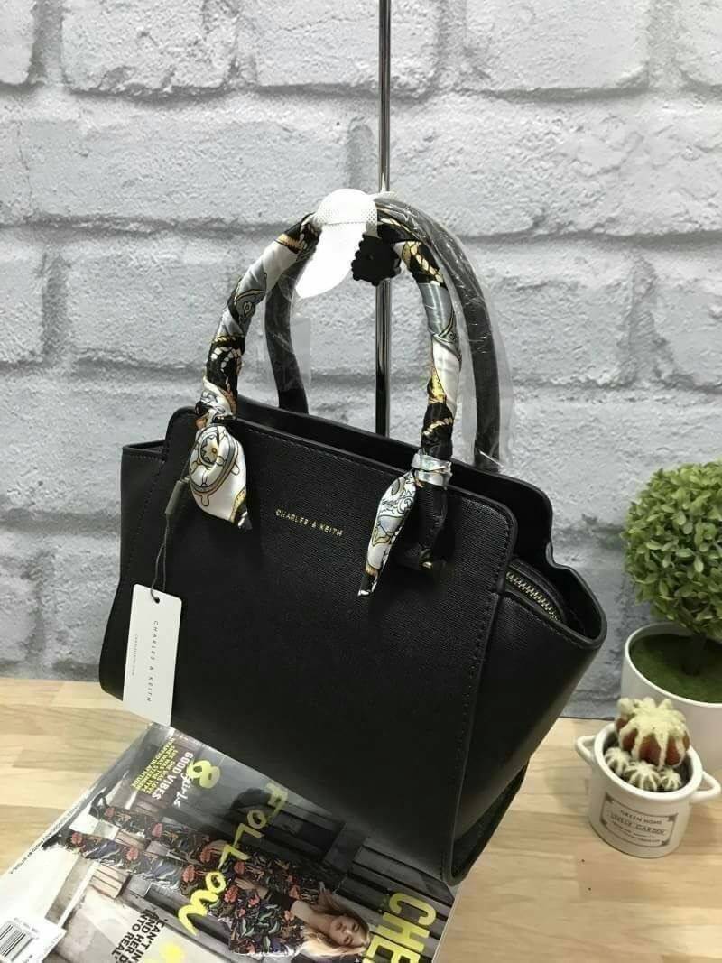 CHARLES&KEITH MINI TRAPEZ BAG พร้อมส่งรุ่นฮิตในตำนานรุ่นขายดี !! !กระเป๋าถือหรือสะพายหนังsaffiano พร้อมสายสะพายยาว115cmปรับความยาวได้5ระดับ ด้านล่างมีหมุดรองฐาน ทั้ง4มุม หูจับสูง14cmมีผ้าพันรอบสามารถถอดออกได้ ลายและสีสวยงามเข้ากับกระเป๋า ขนาดกำลังดีและน้ำ