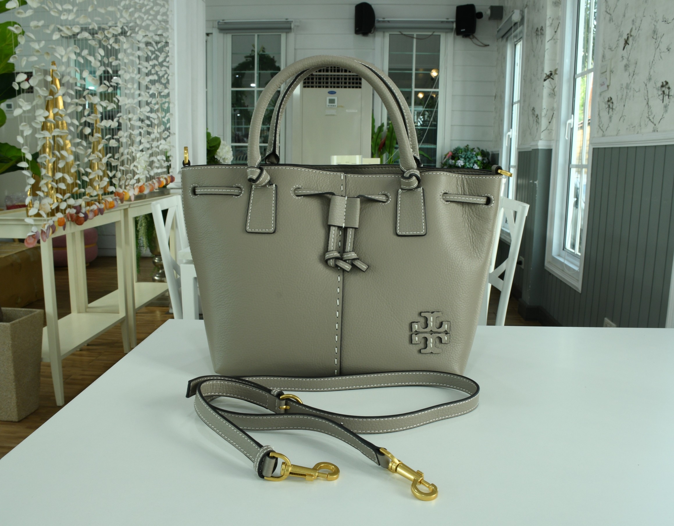OUTLET 】TORY MCGRAW SMALL DRAWSTRING กระเป๋าถือหรือสะพายข้าง วัสดุหนังวัวแท้ อะไหล่ทอง เปิด-ปิดด้วยสายหนังรูด จะถือหรือสะพายข้างได้Crossbodyได้ น้ำหนักเบาจุของได้เยอะ ด้านหน้าประดับโลโก้แบรนด์ ด้านในมีช่องเล็กสำหรับใส่บัตรใส่ตังค์ได้ มีสายยาว ปรับสายได้ ถ