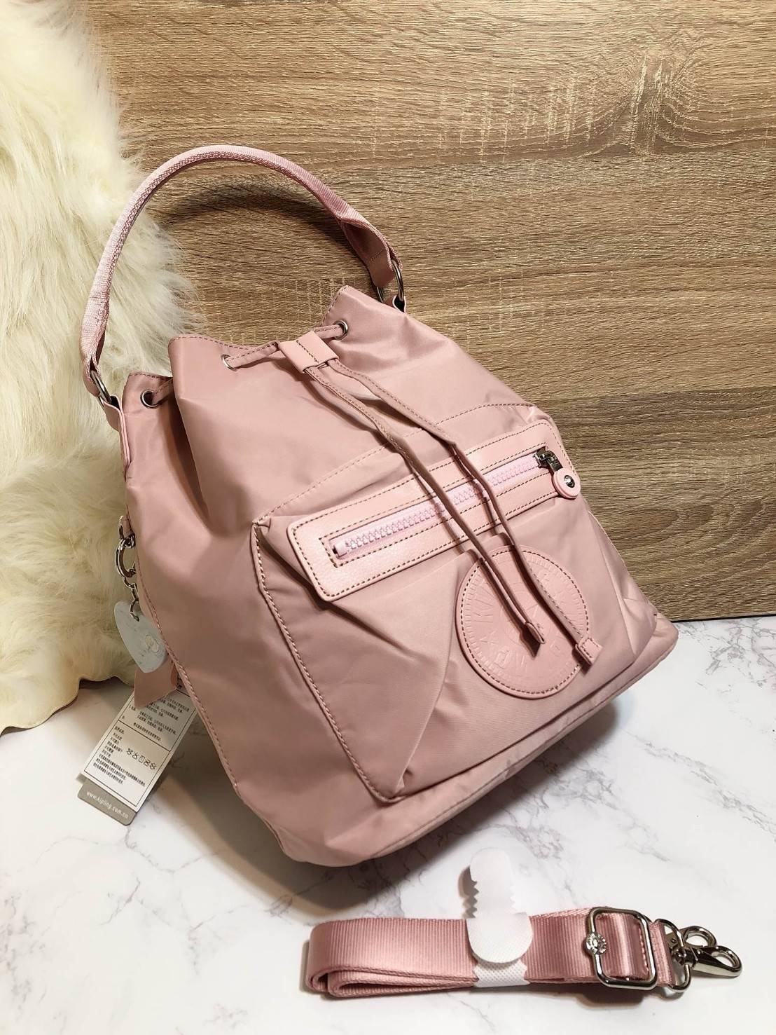 Kipling 2Way Bucket Bag กระเป๋าถือหรือสะพาย 2Way รุ่นใหม่ทรงขนมจีบวัสดุ Nylon & Polyester 100% น้ำหนักเบา ถือและสะพายได้หลายแบบจะใช้สายยาวสะพาย Crossbody หรือใช้สายคู่สะพายหลังแบบเป้ก็ดูดี หูจับถนัดมือสะพายไหล่ได้ เปิดปิดแบบ Drawstring พร้อมกระดุมแม่เหล็ก