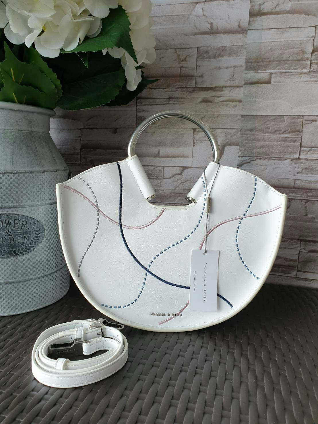 CHARLES & KEITH รุ่น U SHAPE TOP HANDLE BAG CK2-30780786_WHITE ราคาปกติช้อป ( ฿2,590.00 ) กระเป๋าทรงโค้งรูปตัว U วัสดุหนัง PU ลงแพทเทิร์นลวดลาย เส้นด้ายปักแต่งสีสัน บนตัวกระเป๋า เพิ่มความสวยสะดุดตา รับประกันความเก๋!! จะทำให้คุณโดดเด่นไม่เหมือนใคร หูกระเป๋