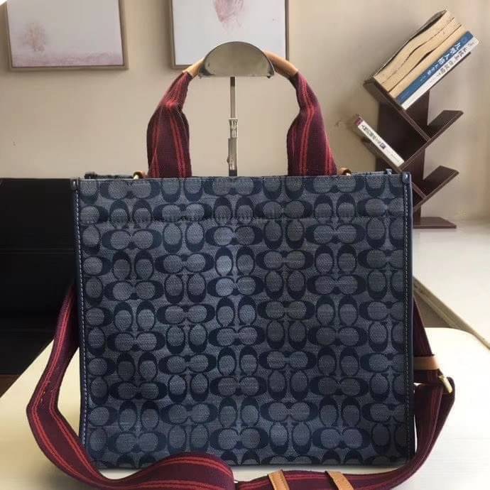 COACH Tote 34 In Signature Chambray หากคุณกำลังมองหากระเป๋าที่มีดีไซน์แปลกตา ไม่ค่อยเหมือนที่พบเห็นทั่วไป ต้องเป็นรุ่นนี้เลยค่ะ นอกจากจะผลิตจากผ้าแชมเบรย์ซึ่งมีน้ำหนักเบาแล้ว ยังให้สีสันคล้ายกับสียีนส์ สายสะพายและหูหิ้วสไตล์สปอร์ต ที่สำคัญยังมีหมุดปิดกระเ