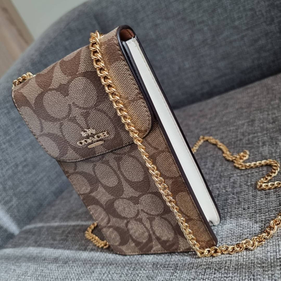 COACH NORTH/SOUTH PHONE CROSSBODY IN SIGNATURE CANVAS F55636 F39955 สุดคลาสสิคกับกระเป๋าสะพายเอนกประสงค์ Case phone ใส่โทรศัพท์มือถือได้ทุกรุ่น ดีไซน์ลายเอกลักษณ์ วัสดุหนังแคนวาสเคลือบลาย ฝาและภายในเป็นหนังสังเคราะห์เรียบ เปิด-ปิดด้วยกระดุม สายสะพายยาวประ