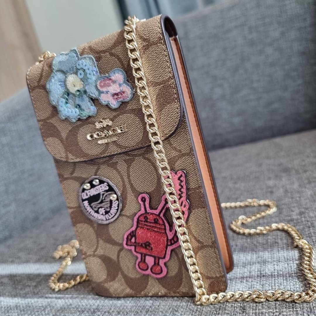 COACH NORTH/SOUTH PHONE CROSSBODY IN SIGNATURE CANVAS F55636 F39955 สุดคลาสสิคกับกระเป๋าสะพายเอนกประสงค์ Case phone ใส่โทรศัพท์มือถือได้ทุกรุ่น ดีไซน์ลายเอกลักษณ์ วัสดุหนังแคนวาสเคลือบลาย ฝาและภายในเป็นหนังสังเคราะห์เรียบ เปิด-ปิดด้วยกระดุม สายสะพายยาวประ