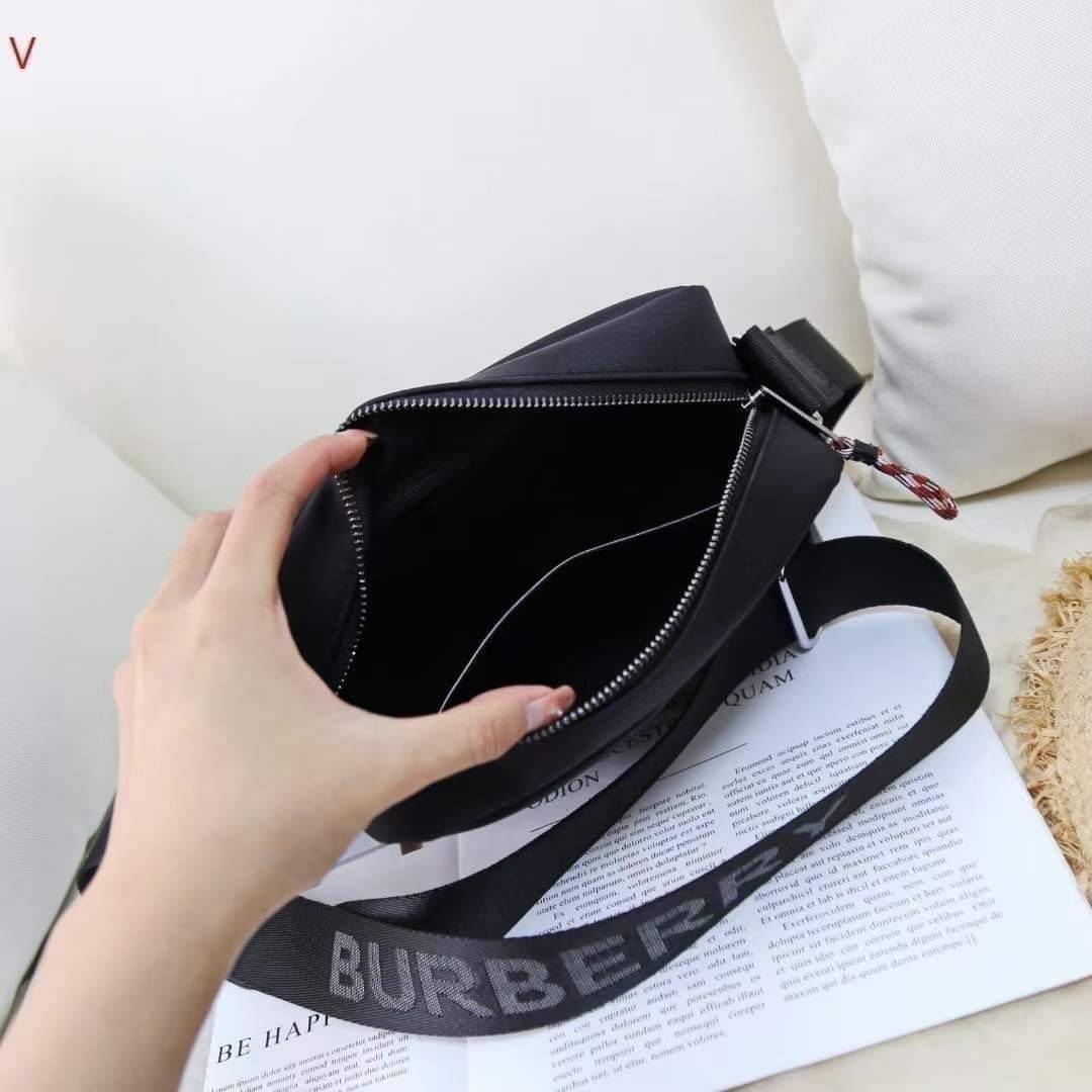 BURBERRY FRAGRANCES CROSSBODY BAG / BURBERRY Nylon Crossbody Bag วัสดุ Nylon Canvas ทรงเหลี่ยมน้ำหนักเบามีโลโก้แบรนด์คาดด้านหน้าพร้อมช่องซิปใส่ของ เปิดปิดด้วยซิปหัวซิปแบรนด์สไตล์สปอร์ต ภายในมีช่องใส่บัตร ขนาดกำลังดีสามารถใส่กล้อง มือถือ กระเป๋าสตางค์ของใช