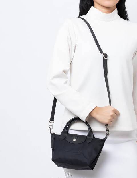 LONGCHAMP LE PLIAGE NÉO TOP HANDLE BAG XS คอลเลคชั่นสุดพิเศษจากลองฌอมป์ มีดีไซน์ที่เรียบหรูและคลาสสิก แฝงด้วยลูกเล่นแบบเฟมินีน แถมยังมีน้ำหนักเบาอย่างไม่น่าเชื่อ มาพร้อมกับหูจับกระเป๋าคู่และฝาปิดแบบกระดุม กระเป๋าถือใบนี้สามารถใช้ถือแบบทั่วไป มีสายสะพายถอด