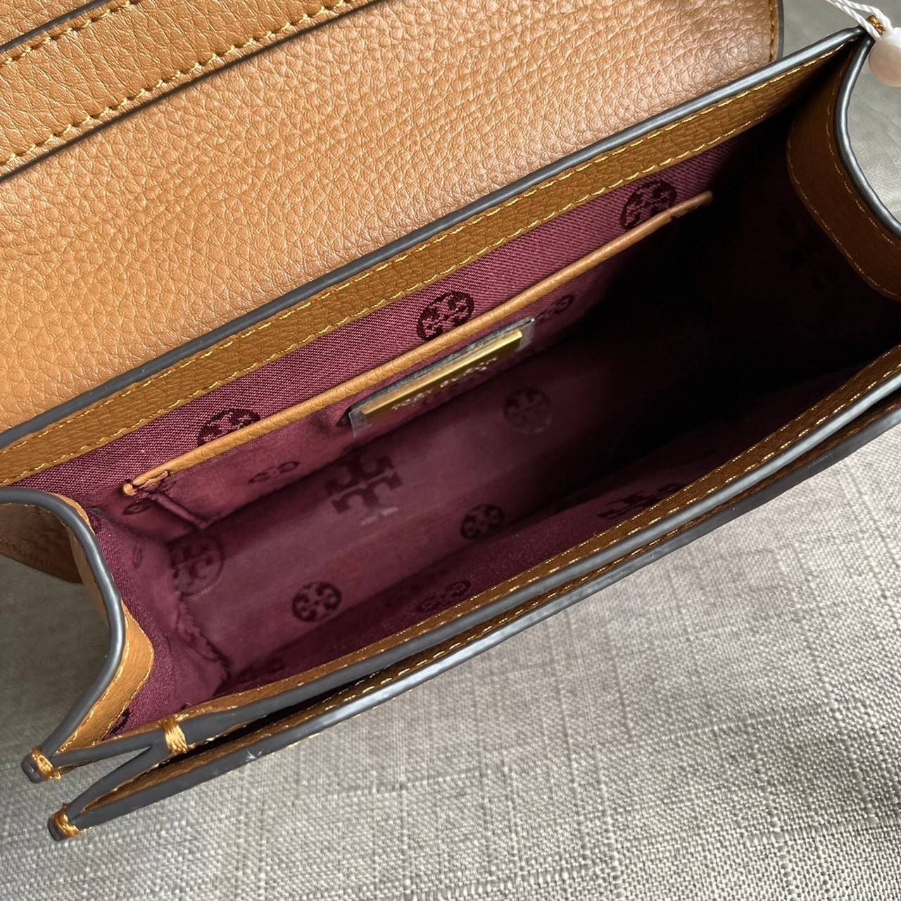 TORY BURCH BRLTTEN SMALL SADDLE BAG / Tory Burch Britten Flap Shoulder Bag กระเป๋าสะพายข้าง วัสดุหนังแกะแท้ ด้านหน้าประดับโลโก้แบรนด์ เปิด-ปิดกระเป๋าแบบกระดุมแป็กแม่เหล็กแน่นหนา ภายในมีช่องหลัก ใส่กระเป๋าเงินใบกลาง มือถือได้ทุกรุ่น มีช่องแยกใส่ของจุกจิกอี