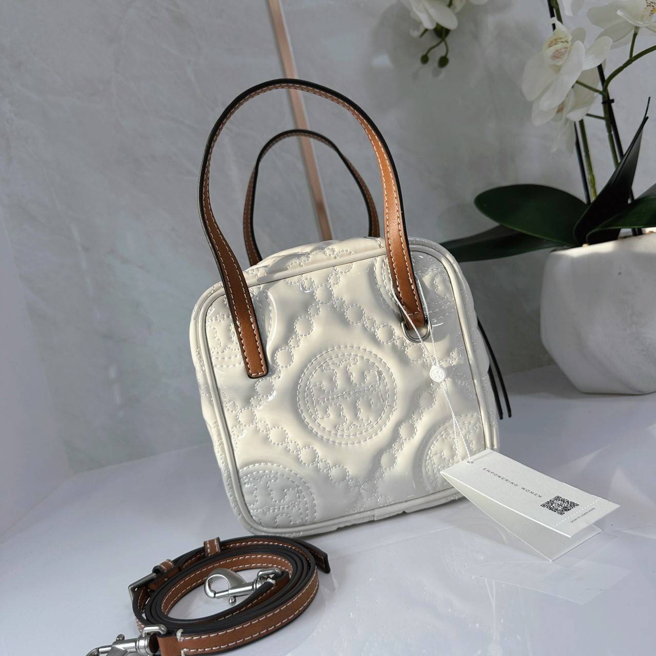 Tory Burch T Monogram Embroidered Patent Cube คอลเลคชั่นใหม่ รุ่นลิมิเต็ดรูปทรงใหม่ T Monogram สุดcube วัสดุหนังแท้ เปิด-ปิดด้วยซิป ภายในกว้าง มีช่องแยก 1 ช่อง สามารถใส่โทรศัพท์มือถือได้ทุกรุ่น สามารถถือหิ้วหรือสะพายได้ สายสามารถถอดและปรับระดับได้คะ