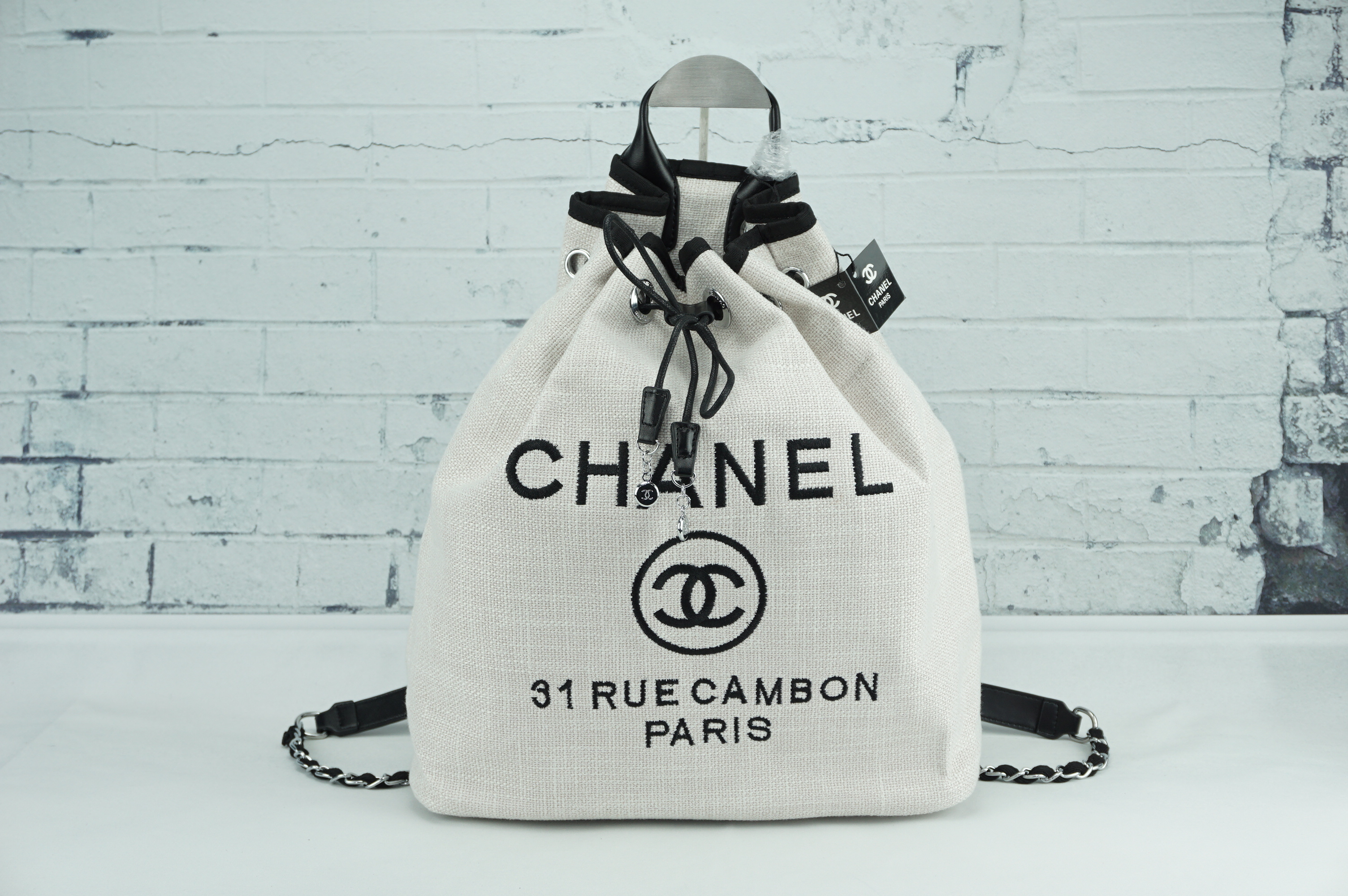 ทรงขนมจีบ premium gift จากแบรนด์ Chanel โลโก้ปัก ผ้า canvas เนื้อหนาอย่างดี มีซับใน ด้านหน้าปักโลโก้แบรนด์หรู จุดเด่นที่เป็นเป้สะพายด้านหลัง หรือสะพายด้านข้างก็ได้