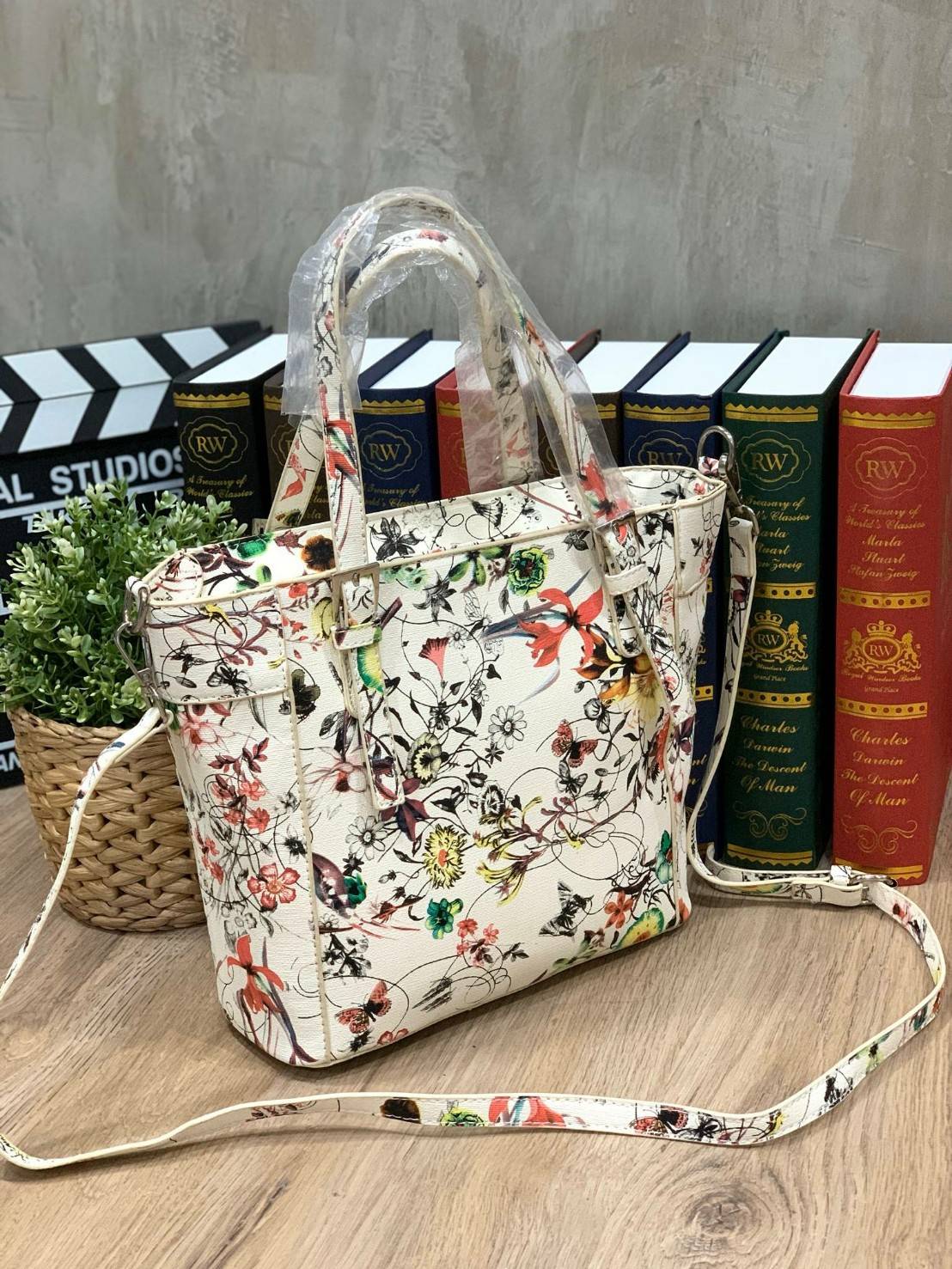 GUESS Women's Medium Floral Tote Bag กระเป๋าถือ คล้องไหล่หรือสะพาย ขนาดกลาง วัสดุหนังpu ลายดอกไม้ชนิดต่างๆรอบใบ เปิดปิดใช้งานด้วยซิปเดียวด้านบน ภายในมีกว้างใส่กระเป๋าสตาวค์ยาว มินิไอแพคได้ หูจับและสายสะพายปรับระดับได้ มาพร้อมกุญแจโลโก้guess สวยน่ารัก