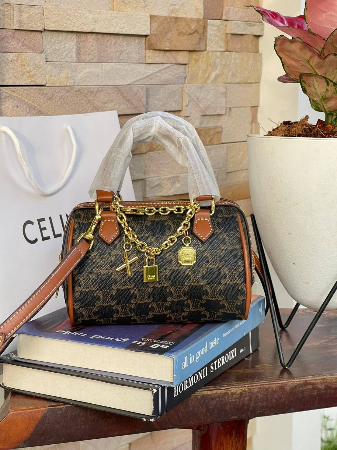 CELINE MINI BOSTON BAG IN TRIOMPHE CANVAS กระเป๋าทรงหมอนขนาดกะทัดรัด เป็นทรงฉิตตบอดกาลไม่มีเอ้าท์ ถือหรือสะพายได้อย่างคล่องตัว ภายในสามารถบรรจุสิ่งของที่จำเป็น สิ่งที่โดดเด่นของกระเป๋าหนังลาย Triomphe ที่ได้รับความนิยมอย่างแพร่หลาย มีอะไหล่ทองประดับเพิ่มม