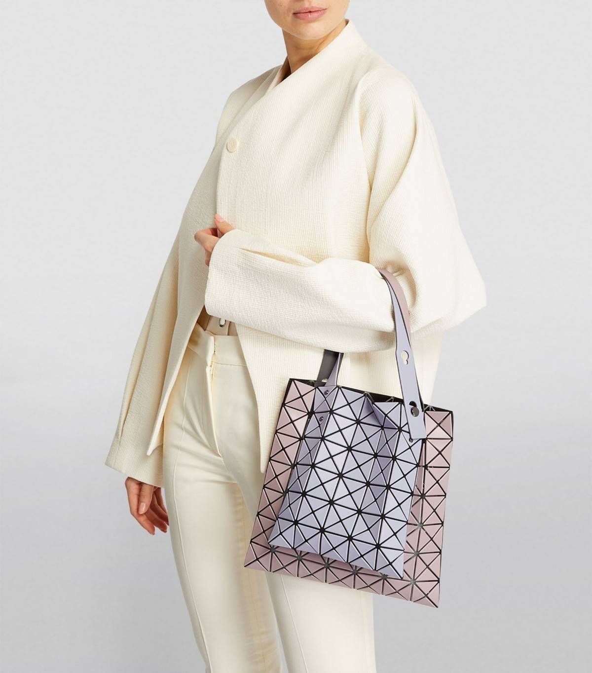 Baobao Issey Miyake Prism Kangaroo tote bag กระเป๋าถือทรงโท้ทที่ประดิษฐ์ขึ้นอย่างเชี่ยวชาญในญี่ปุ่น มาพร้อมแผงเรขาคณิตสำหรับการออกแบบที่ได้รับแรงบันดาลใจจากกระดาษพับ ซิลลูเอทอันเป็นเอกลักษณ์นี้ปิดท้ายด้วยสายรัดแบบอสมมาตร มีการพัฒนาโครงสร้างทรงสามเหลี่ยมเพ