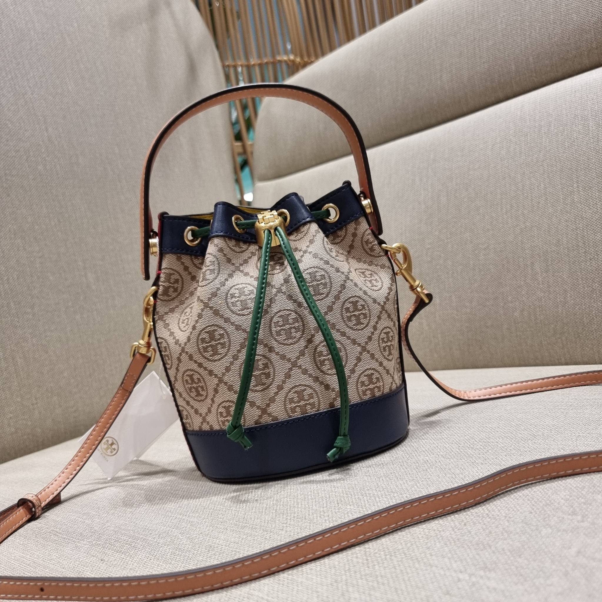 MINI : TORY BURCH T MONOGRAM COLOR-BLOCK JACQUARD MINI BUCKET BAG ใหม่ล่าสุด กับกระเป๋าบัคเก็ตทรงสวย ไซส์มินิ ในราคาน่ารัก โดดเด่นด้วยลวดลายเอกลักษณ์ ผสานลายคัลเลอร์บล็อค โทนสีตัดกันอย่างลงตัว ถักทอบนวัสดุ woven jacquard ลายคมชัด สลับส่วนของหนังแท้ ภายในเ