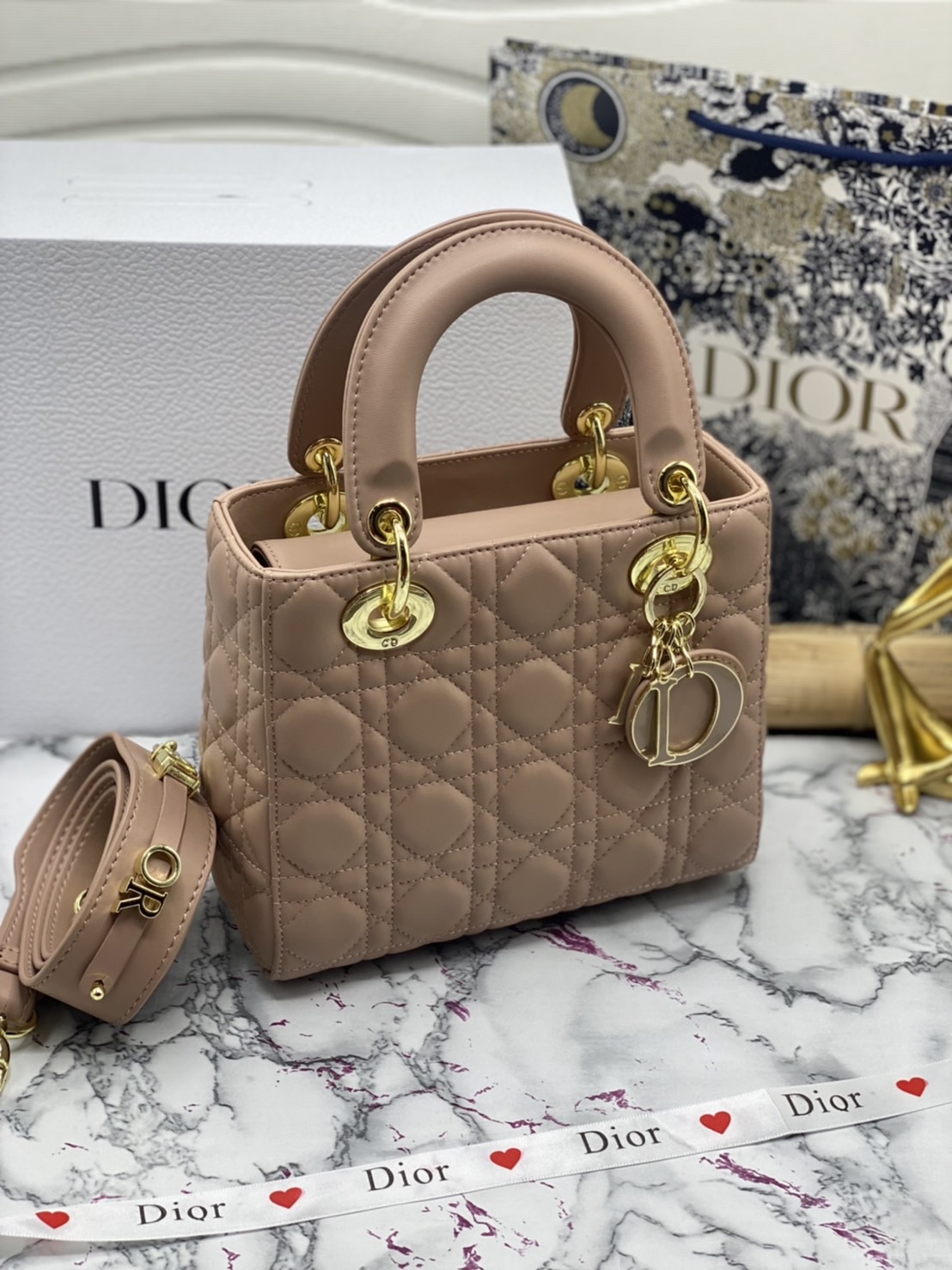 หนังแท้ DIOR LADY BAG 20cm ความสง่างามอีกหนึ่งรุ่นของ Dior รูปทรงสีเหลียม ขนาดกระทัดรัด ตั้งอยู่ทรง ฐานกระเป๋าแข็งแรง มีหมุดรองฐาน ดีไซน์ที่มีเอกลักษณ์เฉพาะตัว ด้านหน้าตกแต่งด้วยตัวอักษร D.I.R ห้อยเป็นพวงกุญแจ จะถือด้วยมือหรือสะพายไหล่ก็ดูดีมากๆ ค่ะ