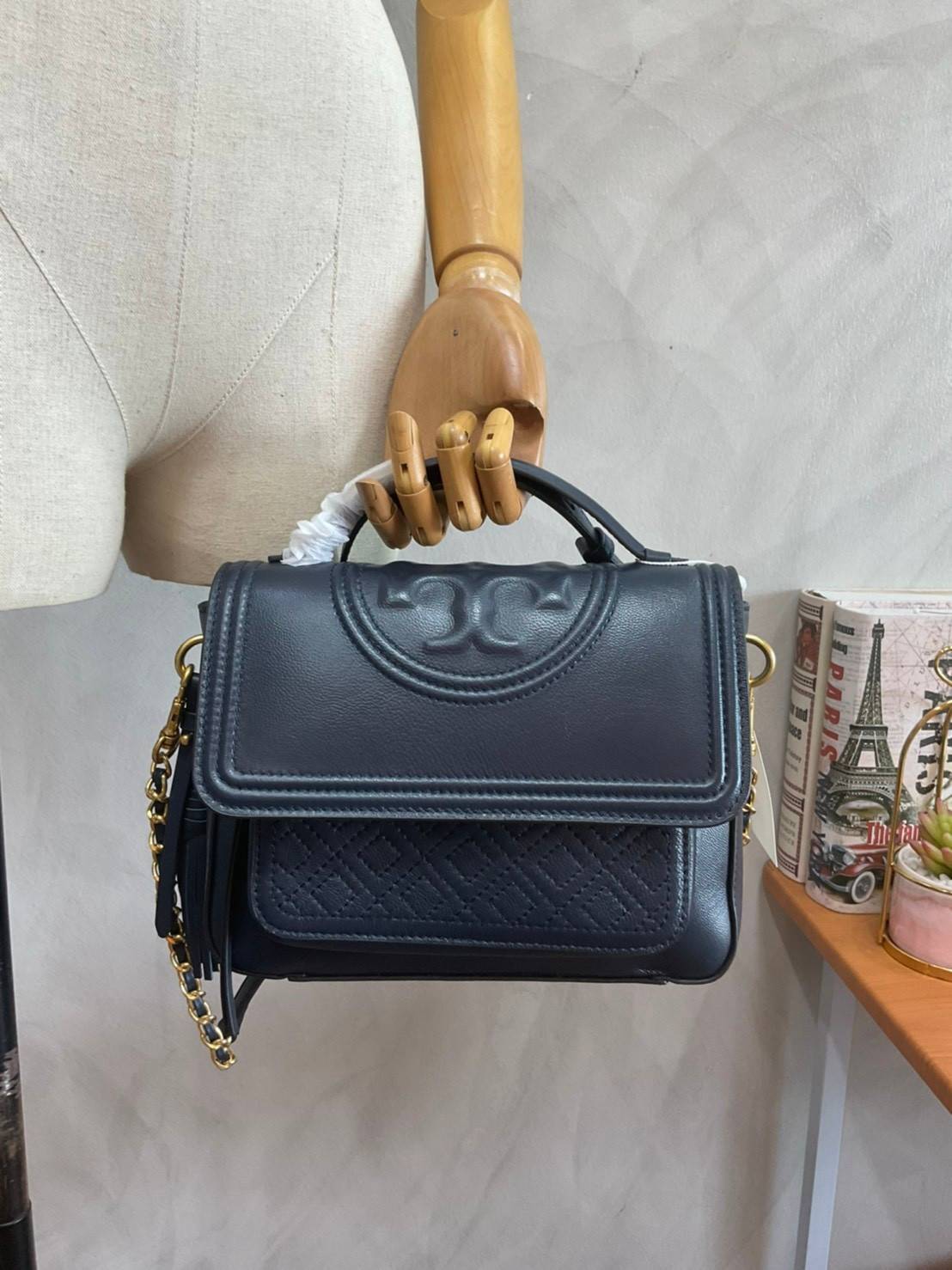 Tory Burch Fleming Satchel Bag รุ่น 45147 สี Royal Navy กระเป๋าสะพาย Crossbody ทรงสวย ดีไซน์เก๋ สุดคลาสสิค เพิ่มดีเทลโลโก้แบรนด์บนฝากระเป๋าอัพลุคให้ดูเท่ห์ และ พู่หนังถอดได้ วัสดุหนังแท้ สัมผัสนุ่มมือ หนังสวย น้ำหนักเบา ตั้งอยู่ทรง เปิดปิดด้วยกระดุมแม่เหล