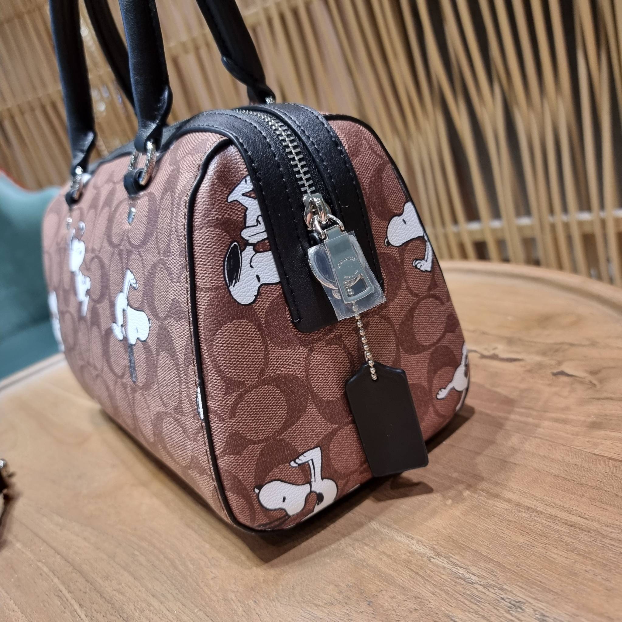 COACH C4118 COACH x PEANUTS ROWAN SATCHEL IN SIGNATURE CANVAS WITH SNOPPY PRINT สนูปพีที่สุดของคอลเลคชั่นแห่งความน่ารัก มาในดีไซน์ของกระเป๋าทรงหมอนยอดฮิต คลาสสิคใช้งานได้ไม่มีเบื่อ รอบนี้มาให้พร้อมสายสะพาย crossbody แบบสปอร์ต ทำให้ใช้งานได้อย่างกระฉับกระเ