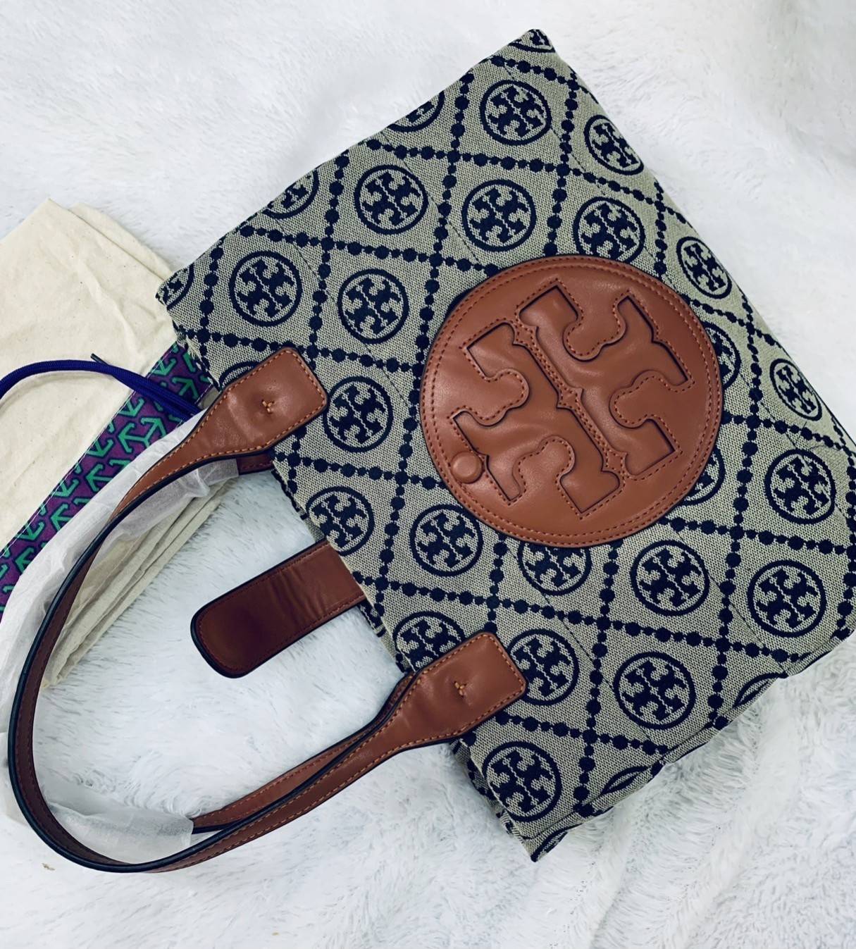 TORY BURCH MONOGRAM TOTE BAG กระเป๋าที่มีเอกลักษณ์เฉพาะตัว วัสดุผ้าแคนวาส Canvas ลวดลายโมโนแกรม เนื้อผ้าหนาสัมผัสนุ่ม โครงสร้างกระเป๋าวัสดุแข็งแรง
