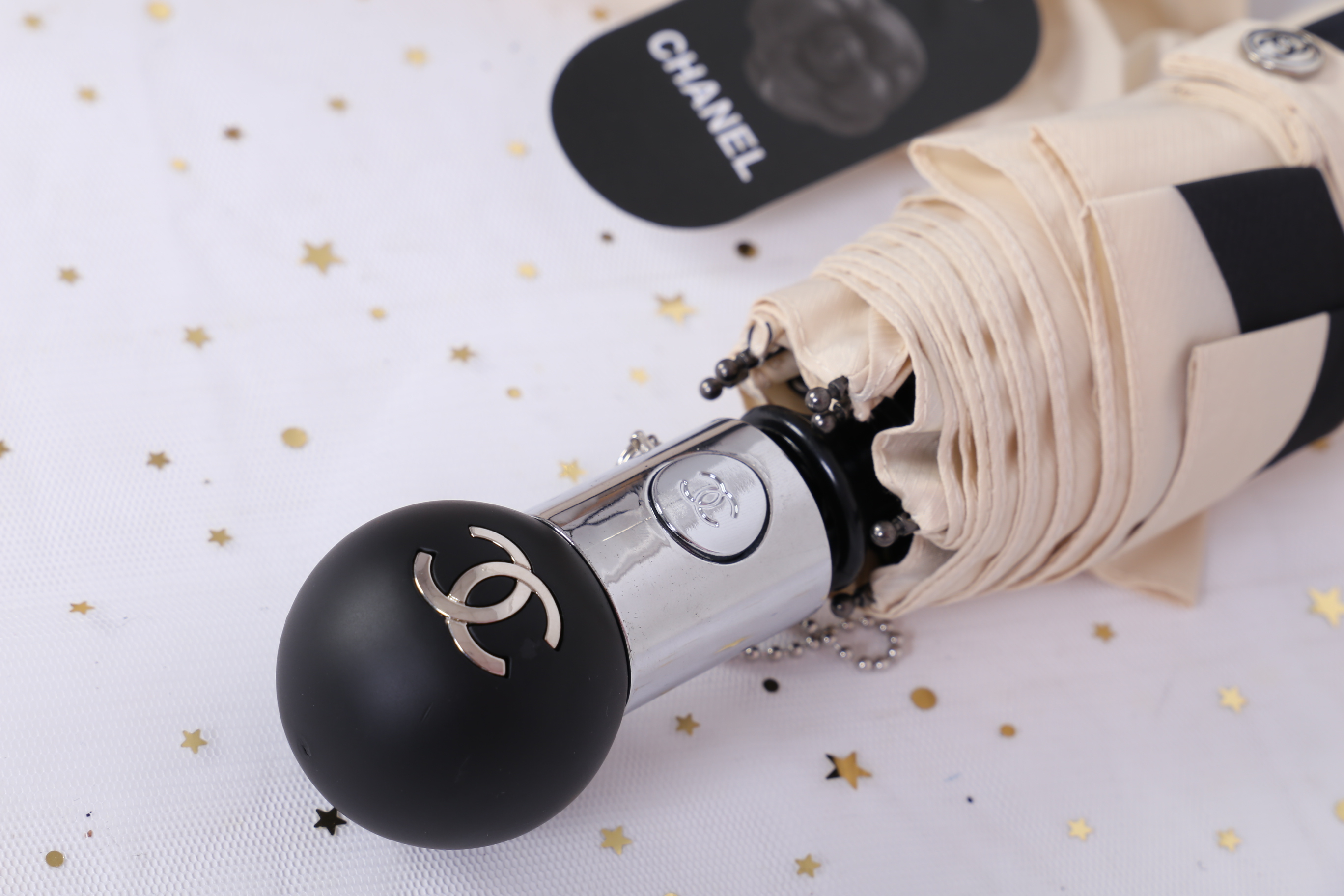 Chanel Umbrella VIP Gift- Black and Beige Camellia With Gift Box Vip Gift Chanel ของแท้ 100% ร่มพับระบบออโต้พรีเมี่ยมจาก Chanel Cosmetic Counter สำหรับกันฝนกันแดด ปกป้องทั้งแดดและฝนพกพาสะดวก ใช้งานง่ายด้วยปุ่มกดออโต้ มาพร้อมปลอกร่ม ภาพถ่ายจากสินค้าจริง สว
