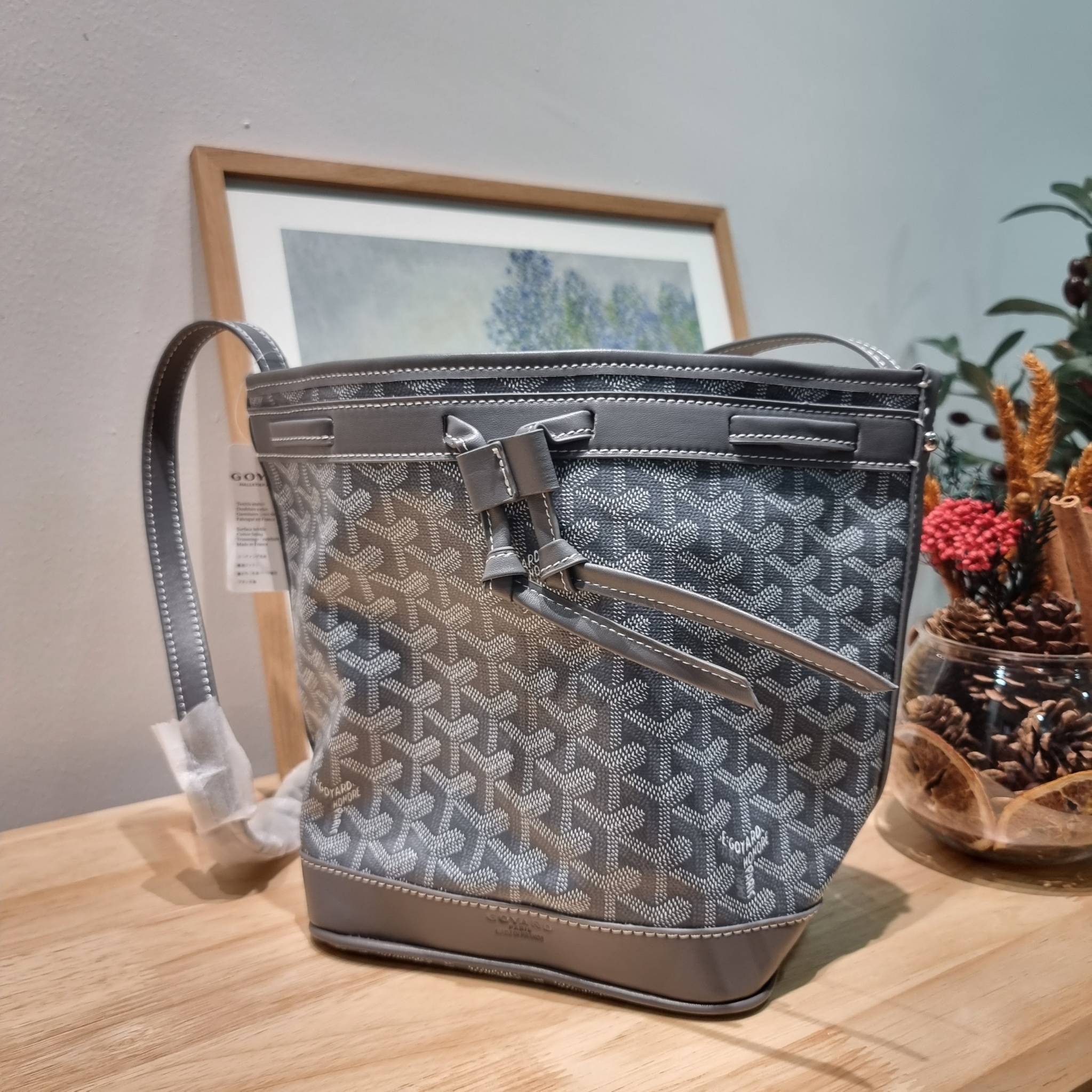 GOYARD PETITE FLOT BUCKET BAG กระเป๋าสะพายทรงบัคเก็ต ที่ดีไซน์สะดวกต่อชีวิตมาก รูปทรงคลาสสิค ดีไซน์เป็นเอกลักษณ์ สดใสทุกสี ดูผู้ดีในตัว วัสดุหนังแคนวาสพิมพ์ลายสวยคม ปากกระเป๋ารูดเปิด-ปิดได้ตามชอบ ภายในเป็นช่องโล่ง ใส่กระเป๋าสตางค์ มือถือ ได้ครบถ้วน มาพร้อ