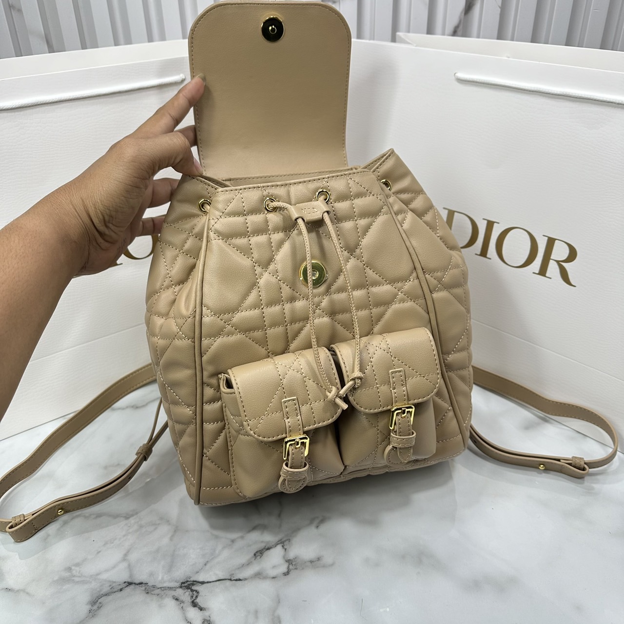 DIOR Medium Dior Caro Backpack Biscuit Macrocannage Leather กระเป๋าเป้สะพายหลังคาโร Cruise 2025 งานหนังเต็มใบ ดีไซส์ทันสมัยและสง่างาม ขนาดกลางใช้งานง่าย 🤍 สินค้าเกรดออริจินอล 1:1 หนังแท้ สลับแท้