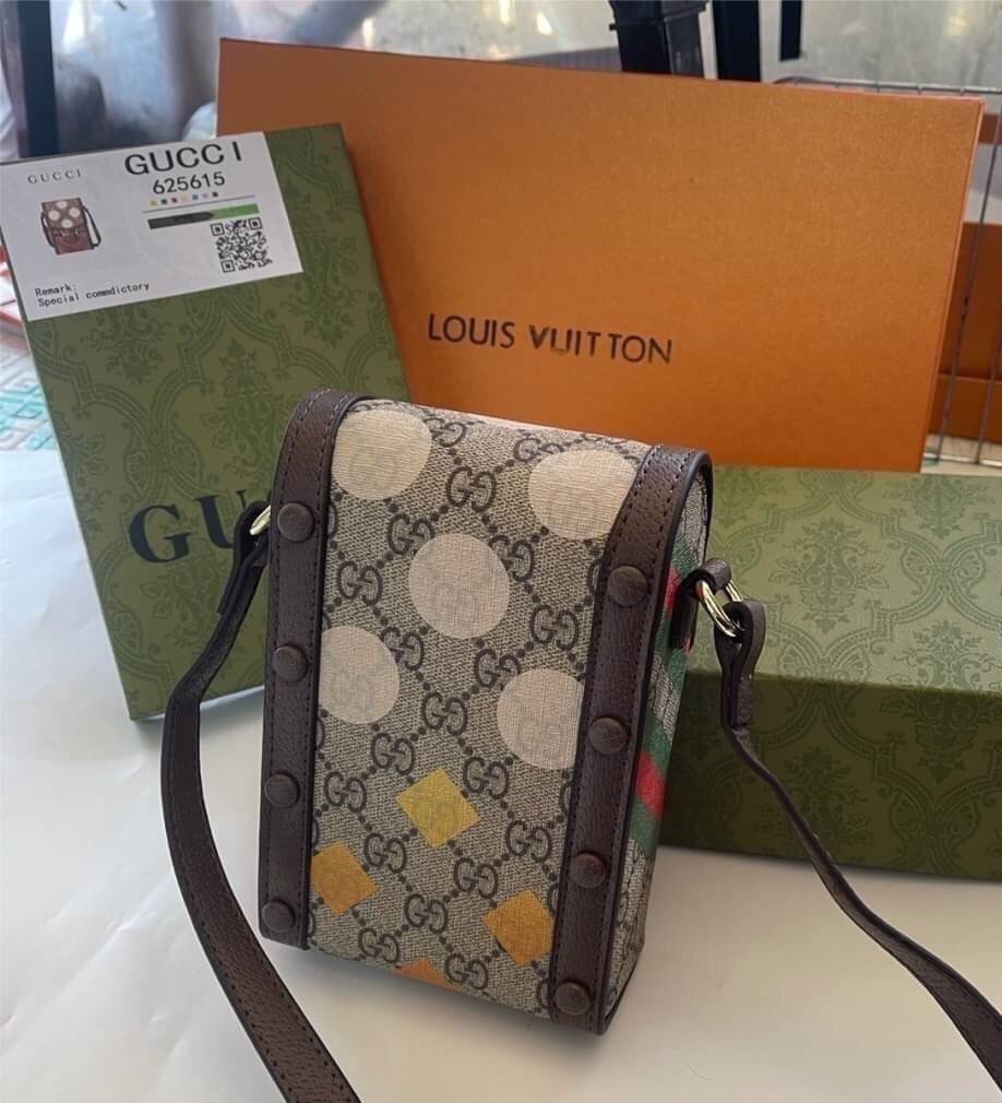 VIP 】GG CANVAS AND LEATHER CROSS-BODY PHONE BAG พร้อมส่งที่ไทย Brown canvas Brown Ophidia GG Supreme mini bag from GUCCI featuring an adjustable shoulder strap, a foldover top, a GG Supreme pattern, a Web stripe to the front and a gold-tone Double G plaqu