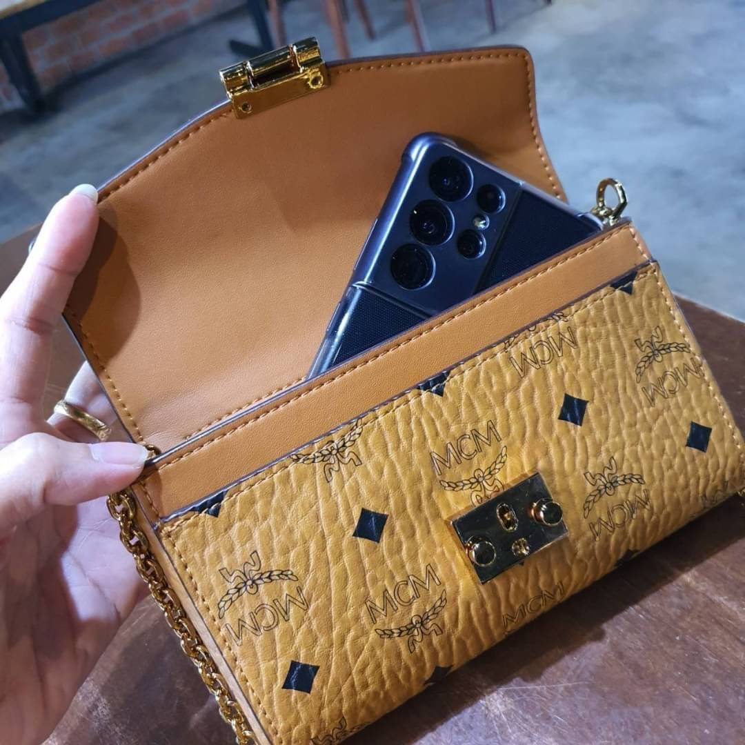 M.C.M SMALL MILLIE FLAP CROSSBODY IN VISETOS ไซส์ใหม่พกพาสะดวก!! กระเป๋าสะพายกึ่งคลัทช์ รอบนี้มาไซส์สวย สามารถใช้แทนกระเป๋าสตางค์ได้เลย ใส่โทรศัพท์มือถือได้ทุกรุ่น ใส่ของสำคัญสบายๆ มาพร้อมสายสะพายโซ่สีทองหรูหรา รูปทรงดีไซน์ร่วมสมัย ใช้งานง่ายด้วยตัวล็อค ว