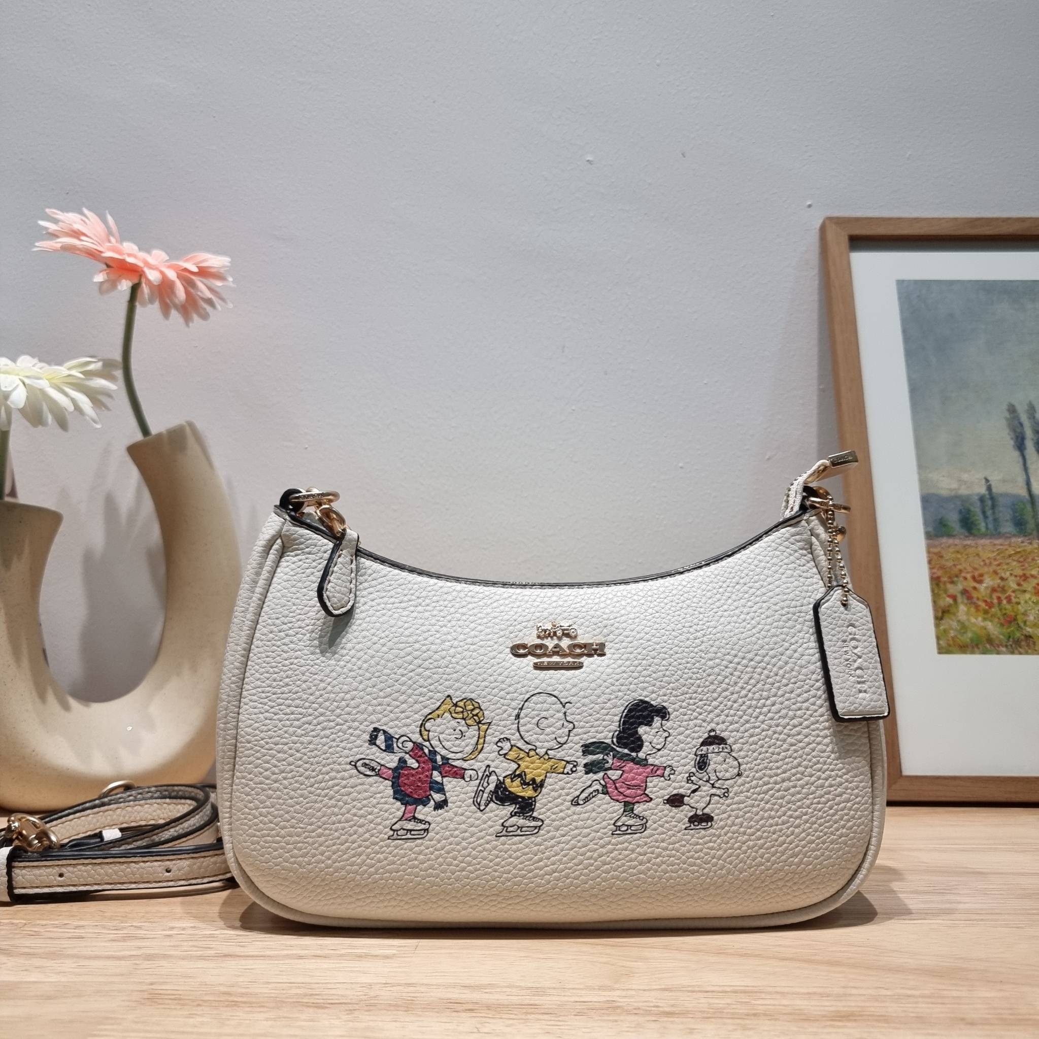 Coach X Peanuts Teri Shoulder Bag With Snoopy And Friends Motif CE861 คอลเลคชั่นสุดคิ้วท์ ไม่ให้ช้อปยังไงไหว!! กับกระเป๋าสะพายไหล่กึ่งทรงพอช พร้อมเสิร์ฟความสวยถึงบ้านไปเลยก่อนใคร แบบไม่ต้องพรีฯ ด้วยดีไซน์ลวดลายกาน์ตูนยอดฮิต มาพร้อมสายสะพาย 2 เส้น