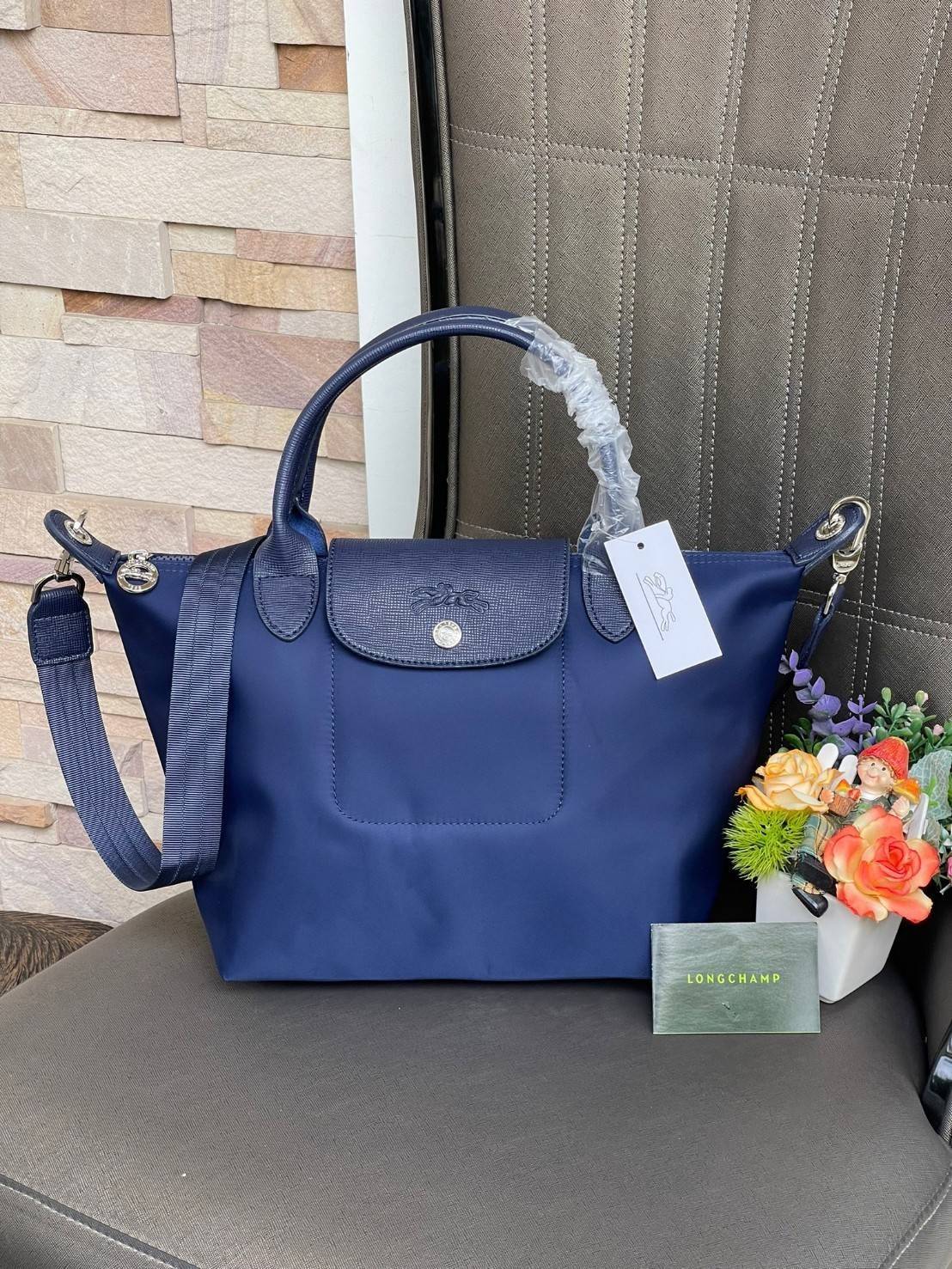 Longchamp Le Pliage Neo Size S มาพบกับกระเป๋ารุ่นยอดนิยม ที่สาวๆ ต้องมีไว้เก็บไว้สักใบ กระเป๋าโท้ทใบนี้ มาพร้อมกับสีที่มีสไตล์เรียบง่าย มีสายสะพายยาวช่วยให้คุณสามารถสะพายไหล่ได้อย่างสบาย ในขณะที่ที่ปิดแบบซิปช่วยให้คุณมั่นใจได้ว่าของด้านในมีความปลอดภัย Le 