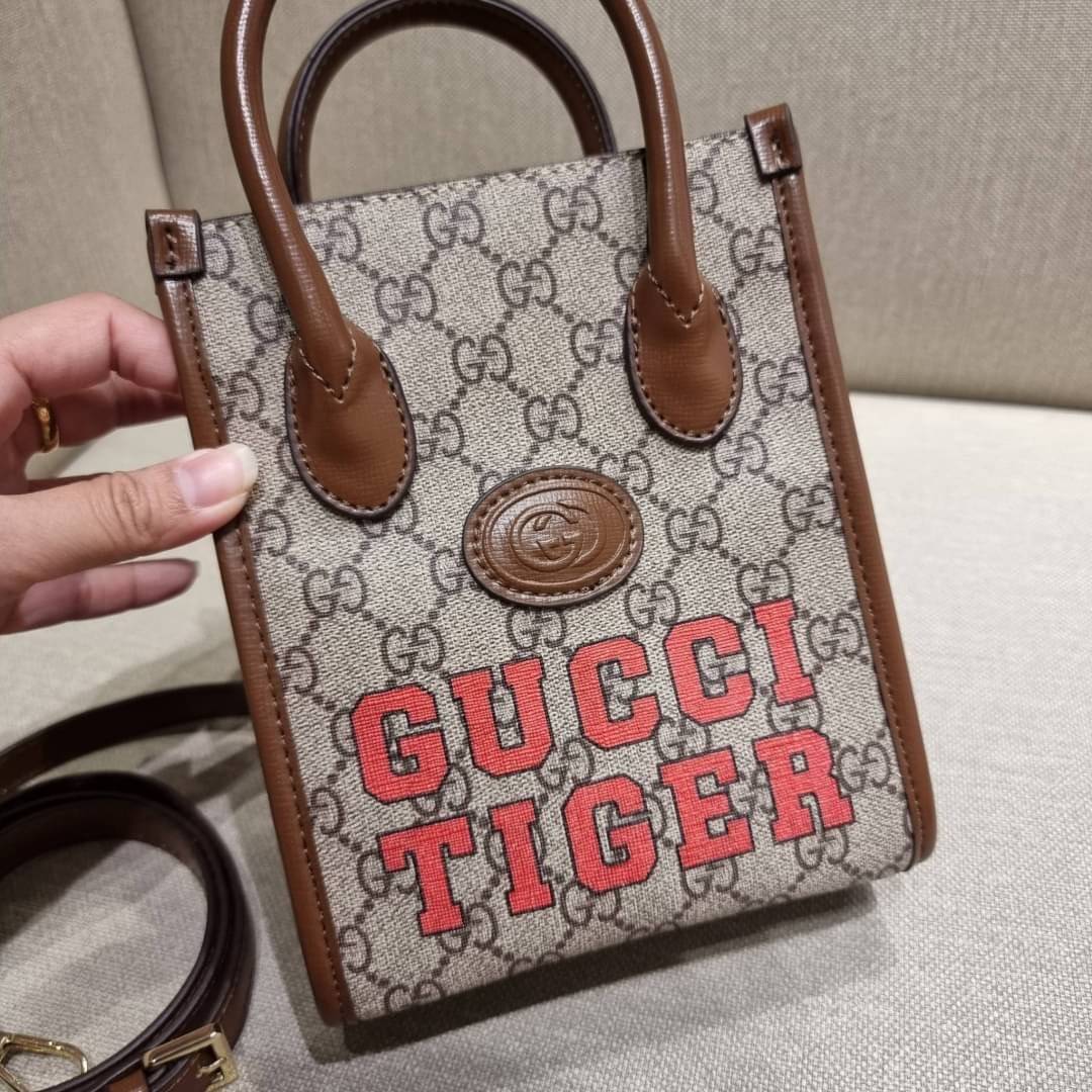 GUCCI Tiger GG mini tote bag ไซส์มินิ ร้อนแรงไฟลุก!! ต้อนรับปีเสืออย่างเป็นทางการ จัดให้แบบเลิศๆ กับกระเป๋าทรงโท้ท วีไอพีพรีเมี่ยมกิ๊ฟ ไซส์มินิ โดดเด่นด้วยฟอนท์ตัวใหญ่ สวยเอกลักษณ์ วัสดุหนังแคนวาสตัดขอบด้วยหนังแท้ ภายในเป็นช่องโล่ง ใส่ของจุกจิกได้ ใส่โทรศ