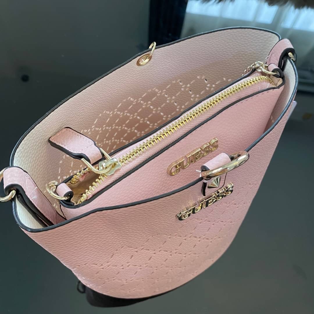 Guess Amara Bucket Handbag ซื้อ 1 ได้ถึง 2 กระเป๋ารุ่นใหม่ล่าสุดทรงถังสุดน่ารัก พิมพ์ลายรอบใบ วัสดุหนังนิ่มคุณภาพดี นิ่ม น้ำหนักเบา ด้านหน้าประดับด้วยโลโก้แบรนด์สวยโดดเด่น เปิด-ปิดด้วยด้วยตัวคล้องอะไหล่เงินสะดวกใช้ ด้านในโล่ง มีสายยาวปรับระดับได้มาให้ มาพ