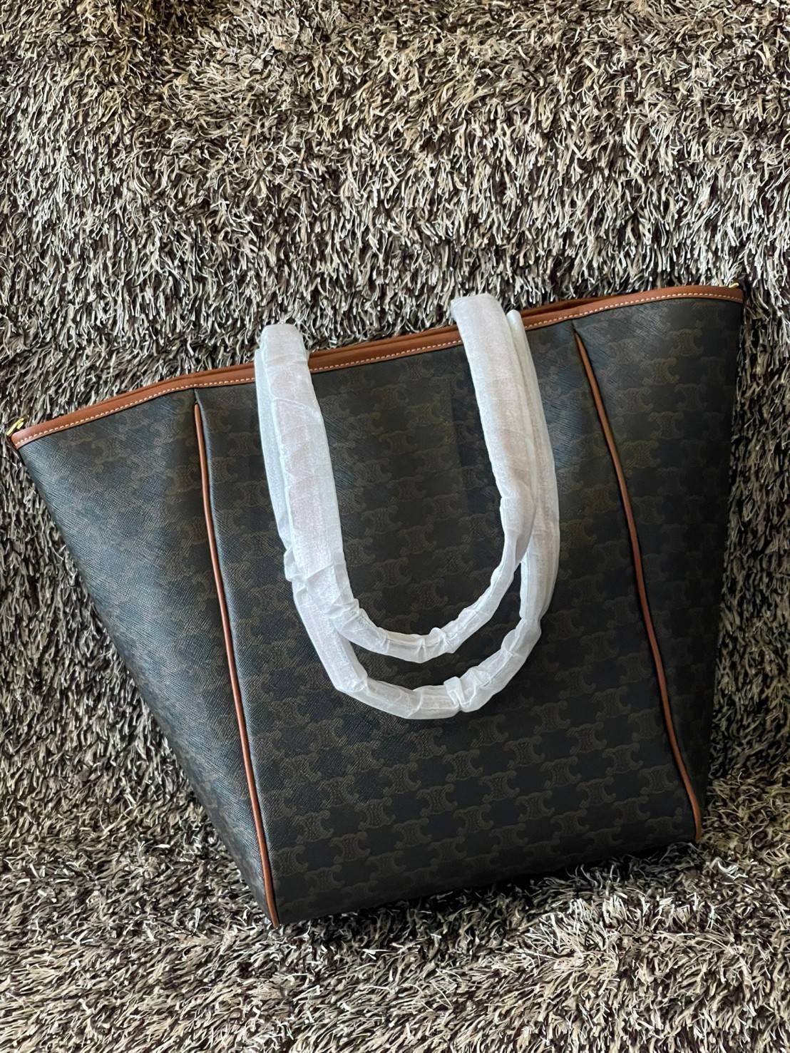 Celine Medium shopping bag in Triomphe canvas มาในรูปแบบ กระเป๋า Shopping Bag ใบสวยสง่า เป็นกระเป๋าดีไซน์เรียบง่าย แมตช์ได้กับทุกชุด ผลิตจากผ้าแคนวาสชนิดพิเศษซึ่งโดดเด่นด้วยลายเอกลักษณ์ของ Triompe เป็นใบที่เหมาะกับการใช้ประจำวันเป็นอย่างมาก ด้วยรูปทรงสี่เ