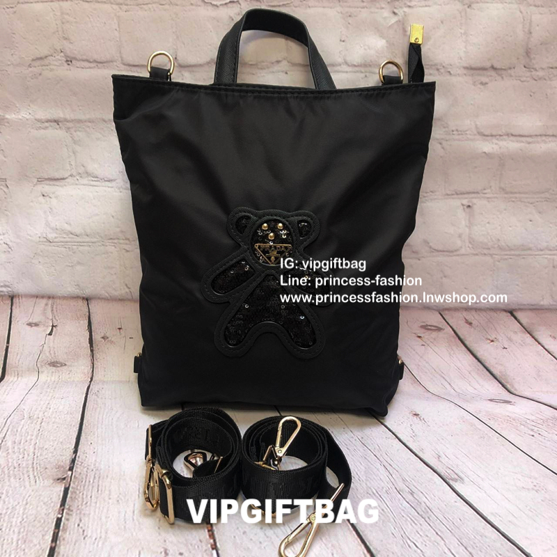 กระเป๋าสะพาย ทรง TOTE จากแบรนด์ PRADA มาค่า ตัวกระเป๋าเป็น nylon ทั้งใบ สะพายเป็น shoulder bag หรือถือได้ค่ะหรือสะพายเป็นเป้ก้ยังได้ ด้านหน้าเป็นลายหมี ปักกลิ้ตเตอร์ + logo brand ใช้แล้วสวยมากๆ อะไหล่ทองหรูมาก จุของคุ้ม ใส่หนังสือหรือของจุกจิกก็ไ้ด้หมด สว