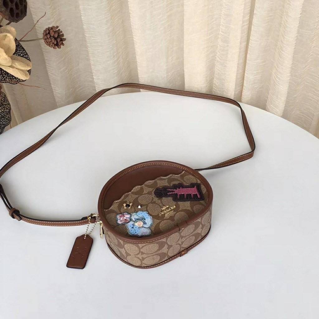 COACH KEITH HARING CANTEEN CROSSBODY IN SIGNATURE CANVAS WITH PATCHES F48730 กระเป๋าทรงกลมสุดเก๋ ไม่เหมือนใคร ตกแต่งลายให้มรความน่ารัก โดดเด่นขึ้นมา สะพายไปไหนก็สวยไม่เหมือนใคร ภายในกว้าง ใส่ของได้เยอะ กระเป๋าเปิดปิดด้วยซิป ใครย้งไม่มี รีบจับ รีบจองกันเลย