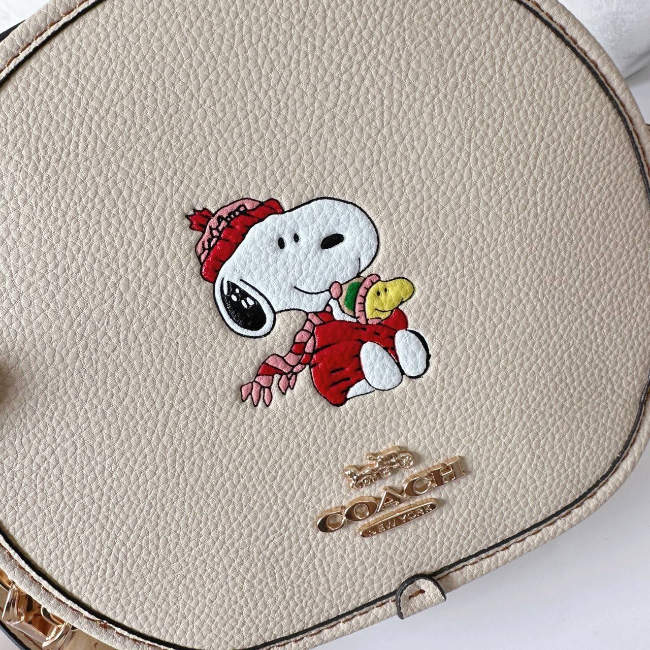 COACH X PEANUTS CANTEEN CROSSBODY WITH SNOOPY PRESENT MOTIF (CE845,CF290) กระเป๋าสะพายข้างทรงกลมไซส์มินิ มีหูจับ วัสหนังแท้ ด้านหน้าโดดเด่นด้วยรูปการ์ตูนSnoopy