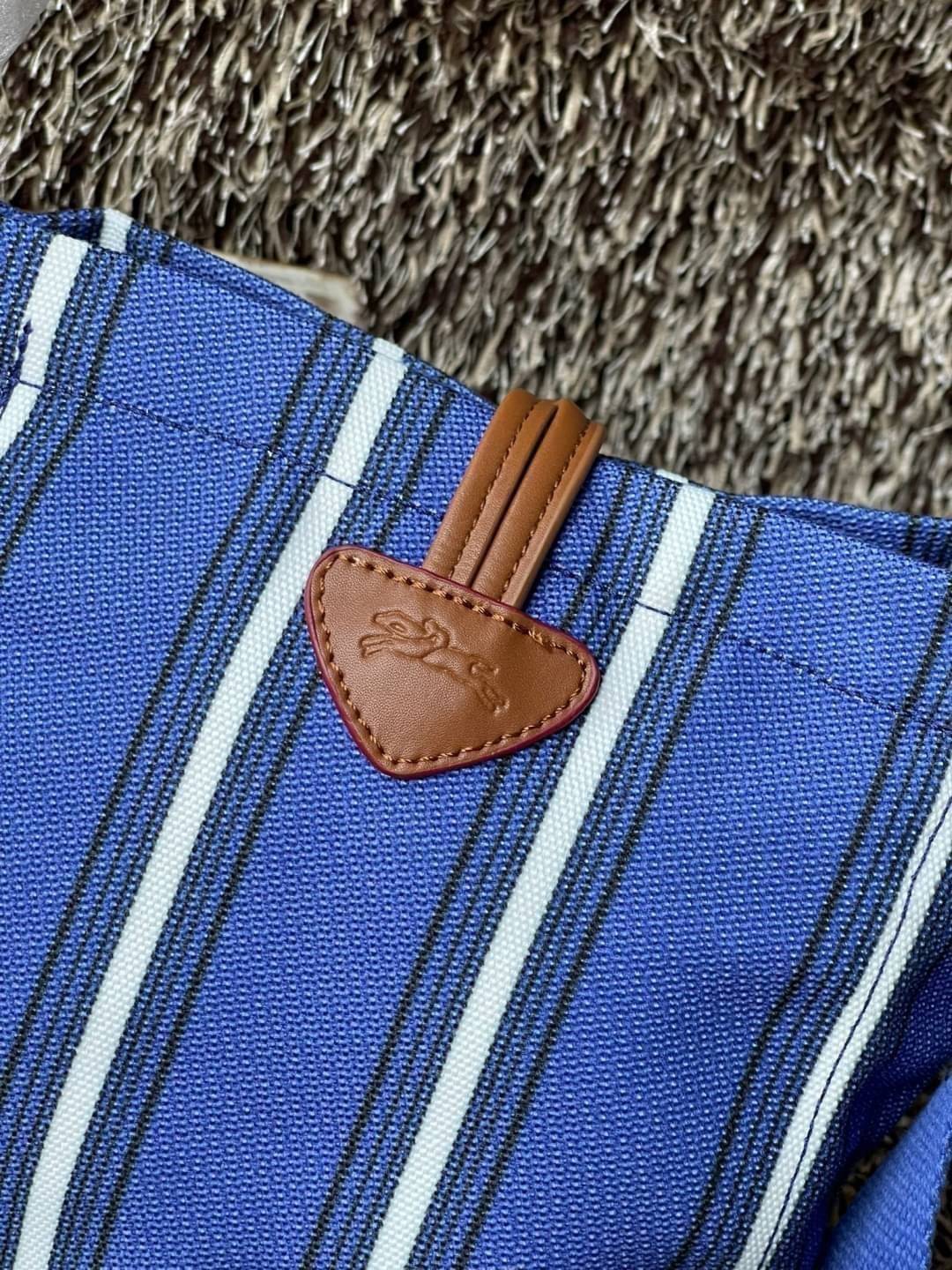 LONGCHAMP ROSEAU ESSENTIAL RAYÉ Bucket bag S - Blue สำหรับใครที่ต้องการกระเป๋าแบบใช้งานได้ในหลาย ๆ โอกาส สีสันกระเป๋าสามารถแมทช์ได้ง่ายกับเสื้อผ้า Longchamp รุ่นนี้สามารถตอบโจทย์ เป็นกระเป๋าที่ขนาดกำลังพอดี