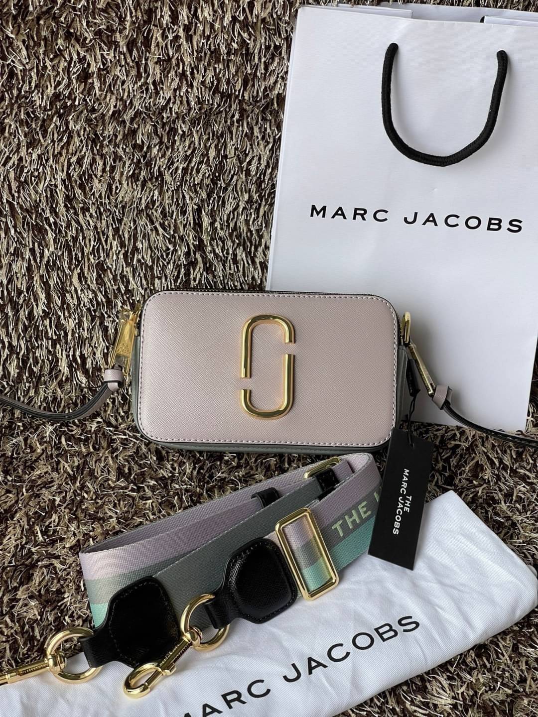 Marc Jacobs Snapshot Bag กระเป๋าแบรนด์ดังจากสัญชาติอเมริกัน นับได้ว่ารุ่นนี้เป็นรุ่นทรงฮิตเลยทีเดียว โดยด้านหน้ากระเป๋าจะเป็นโลโก้แบบโลหะที่เป็นสัญลักษณ์ของแบรนด์นี้ มาพร้อมสายสะพายที่จะสะพายยังไงก็ดูโดดเด่น เพราะขนาดใหญ่ที่สกรีนตัวอักษรโลโก้ ในรูปแบบต่าง