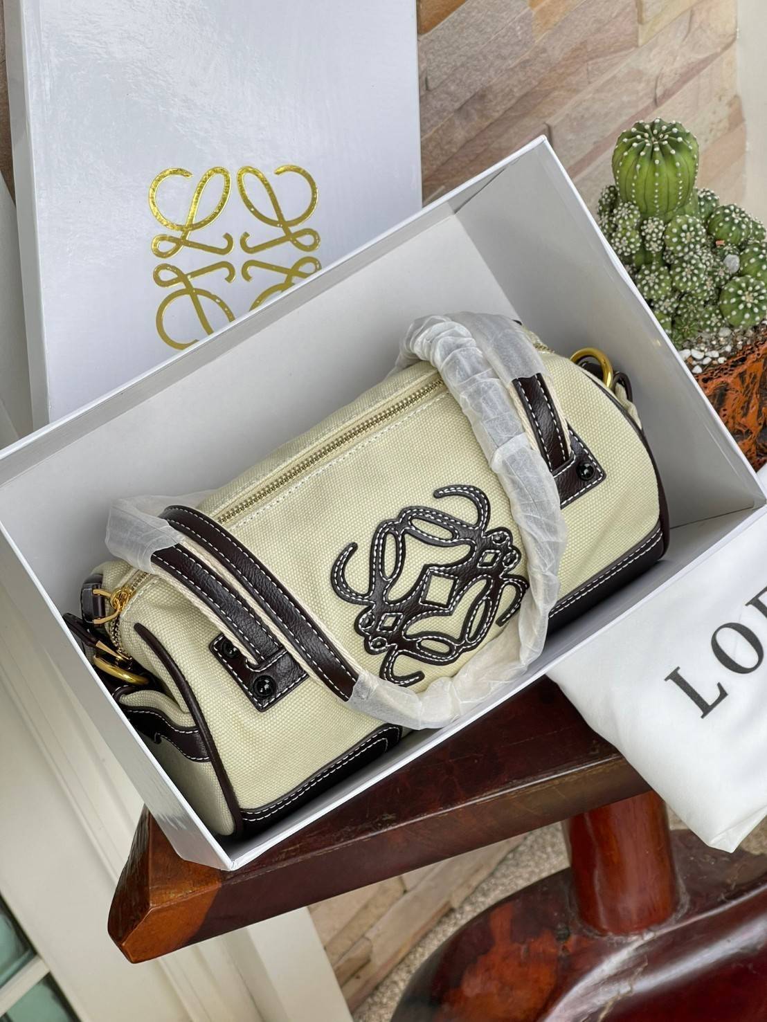 LOEWE ANAGRAM LOGO EMBROIDERED CANVAS VINTAGE MINI SHOULDER BAG กระเป๋าทรงหมอนแบบสะพายไหล่โลเอเว่ ด้านหน้าปักสัญลักษณ์โลโก้แอนนาแกรม สายหนังแท้ เป็นรุ่นที่มีขนาดไม่ใหญ่มาก แต่สามารถใส่ของสำคัญของตนเองเข้าไว้ข้างในได้ครบครัน นอกจากนี้ยังใช้ซิปยาว และซิปสอง