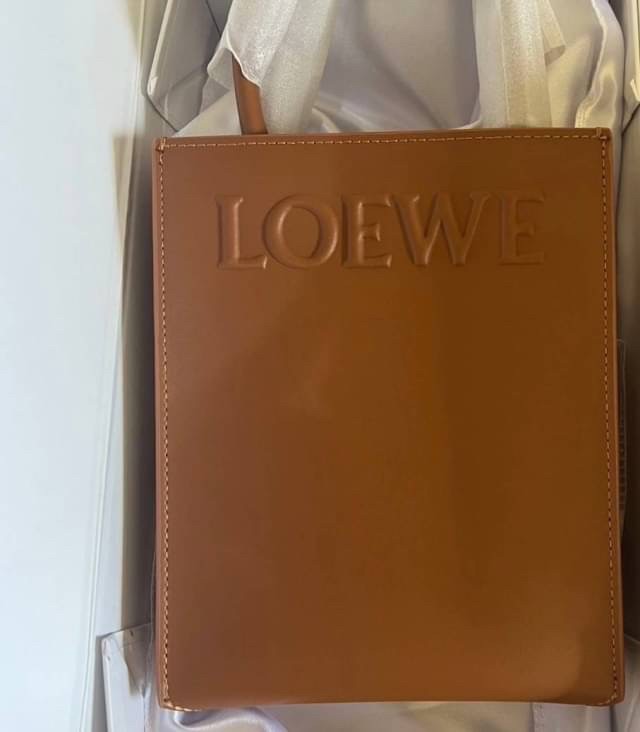 LOEWE Tote Leather Bag พร้อมส่ง กระเป๋าทรงโท้ทหนังเรียบสวยอยู่ทรงด้านหน้ามีโลโก้แบรนด์ หูจับแข็งแรงมาพร้อมสายสะพายหนังเรียบยาวปรับระดับได้จะถือหรือสะพายไหล่สะพายเฉียงก็ดูดี
